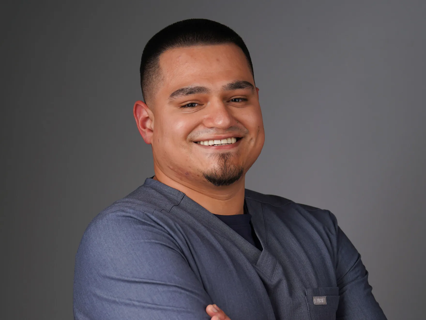 a smiling man with his arms crossed