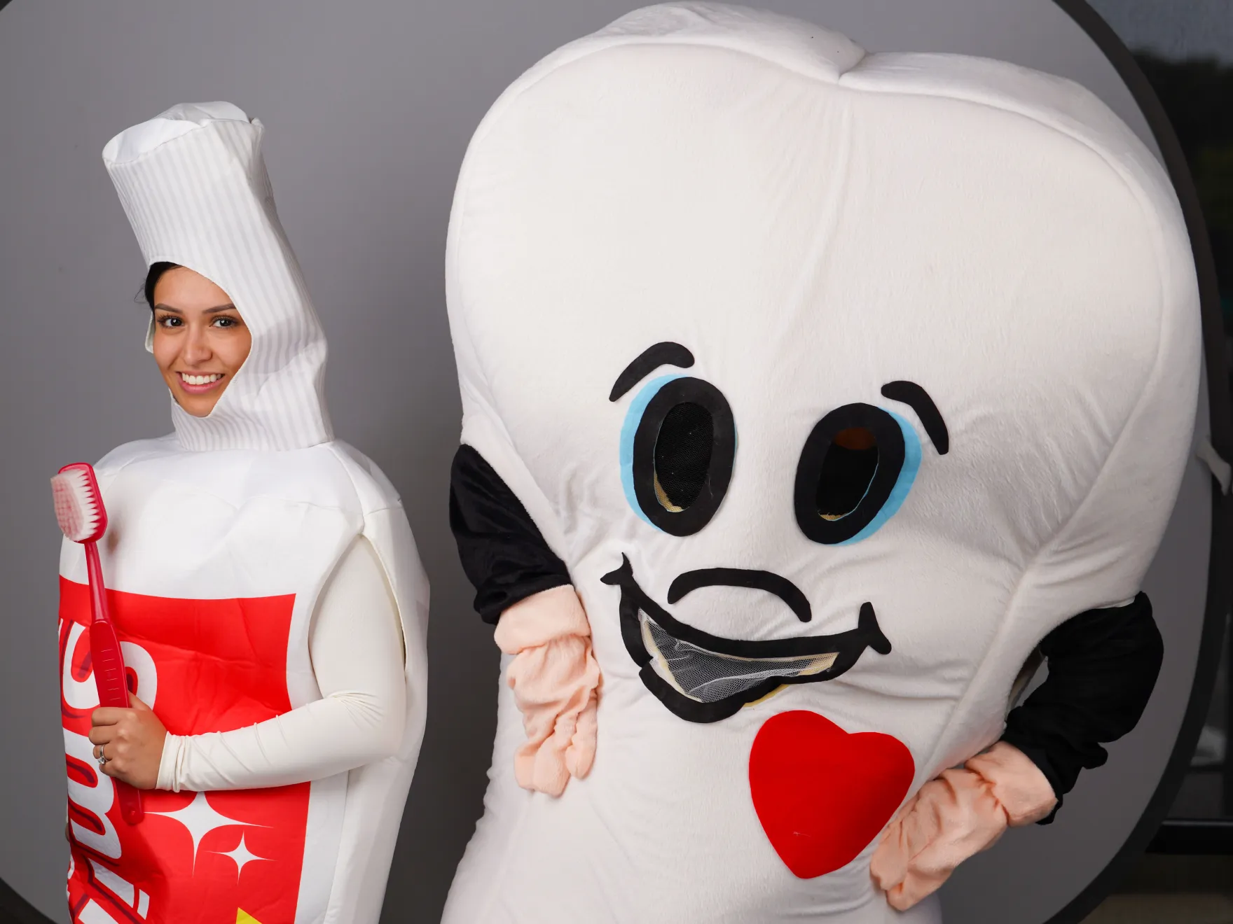 a woman standing next to a giant inflatable character