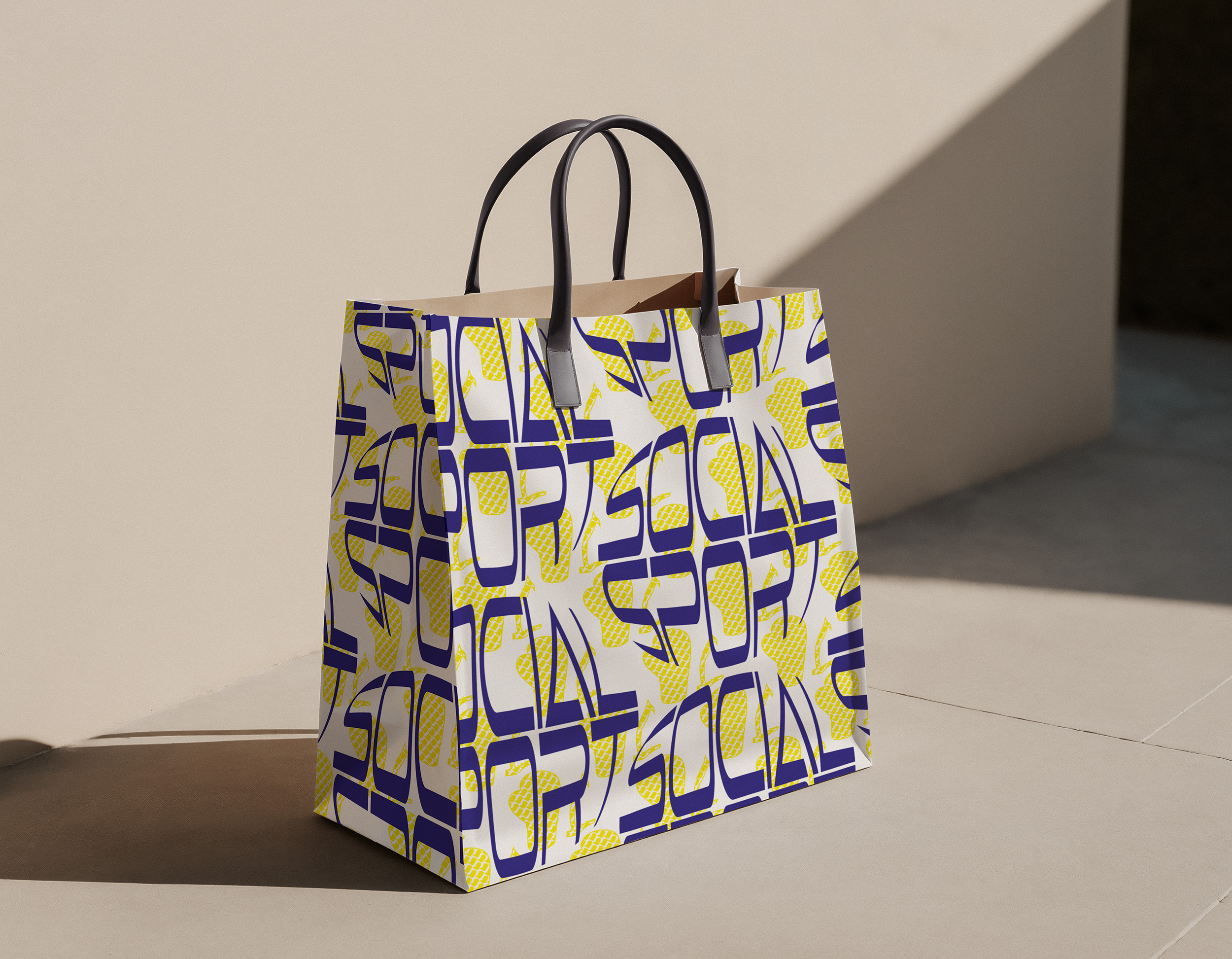 Shopping bag mockup with Social Sport pattern in bold blue typography and yellow sports illustrations.
