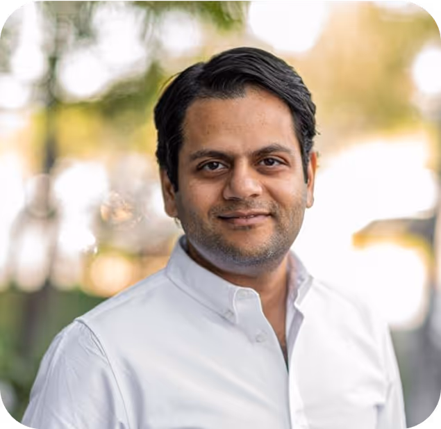 Smiling professional in white shirt against blurred outdoor background