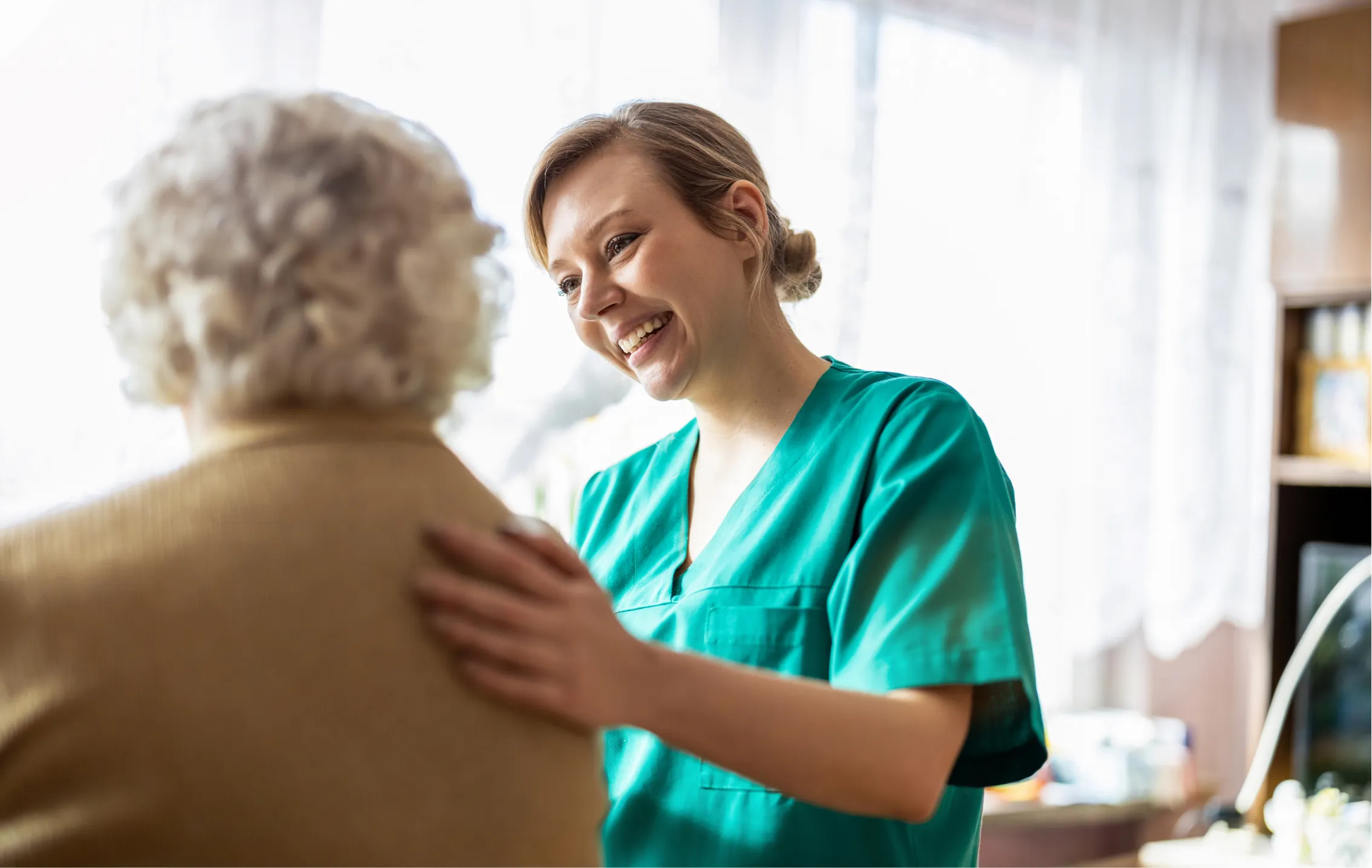 Smiling caregiver with her hand on a client's shoulder