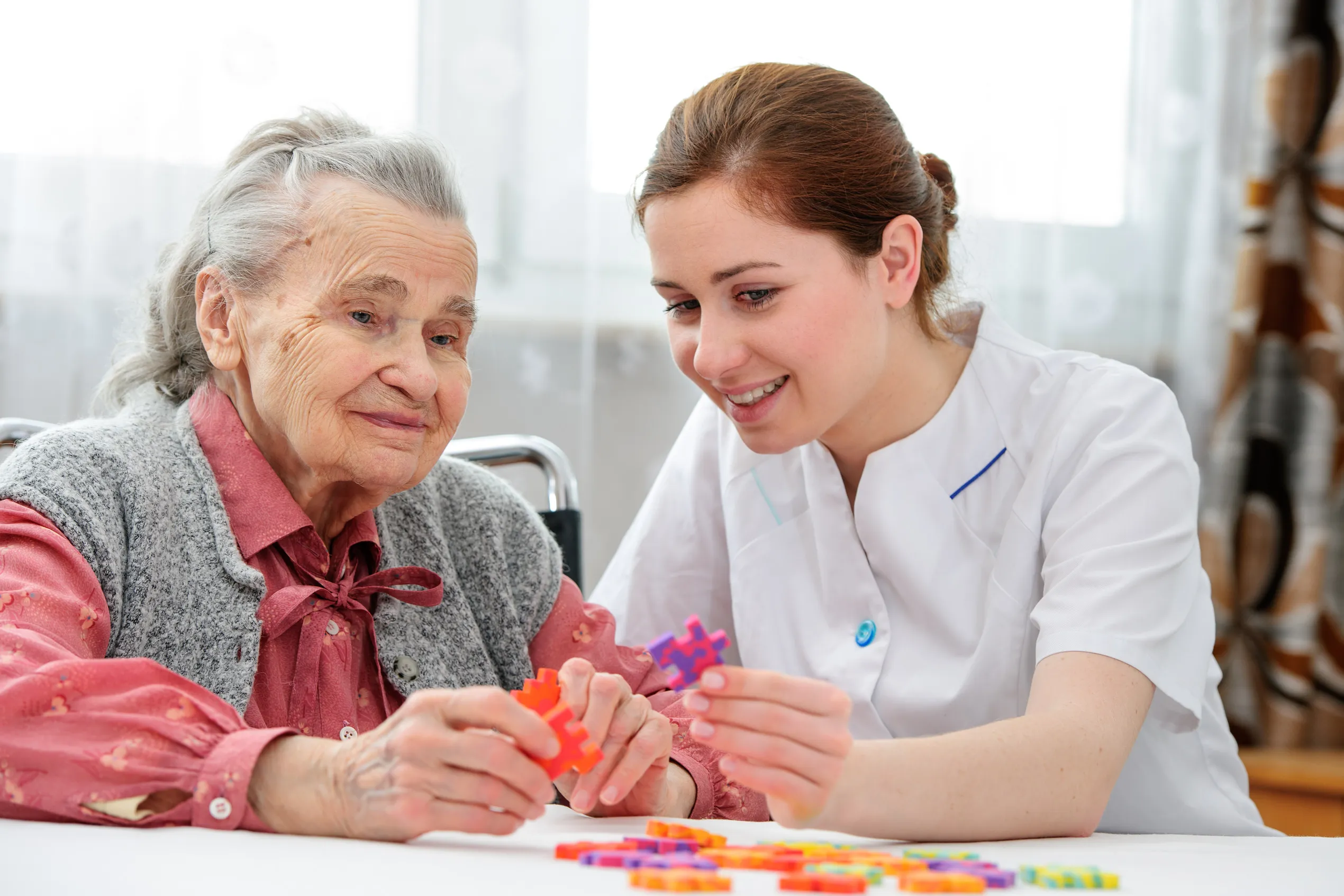 Caregiver doing a puzzle with an older woman