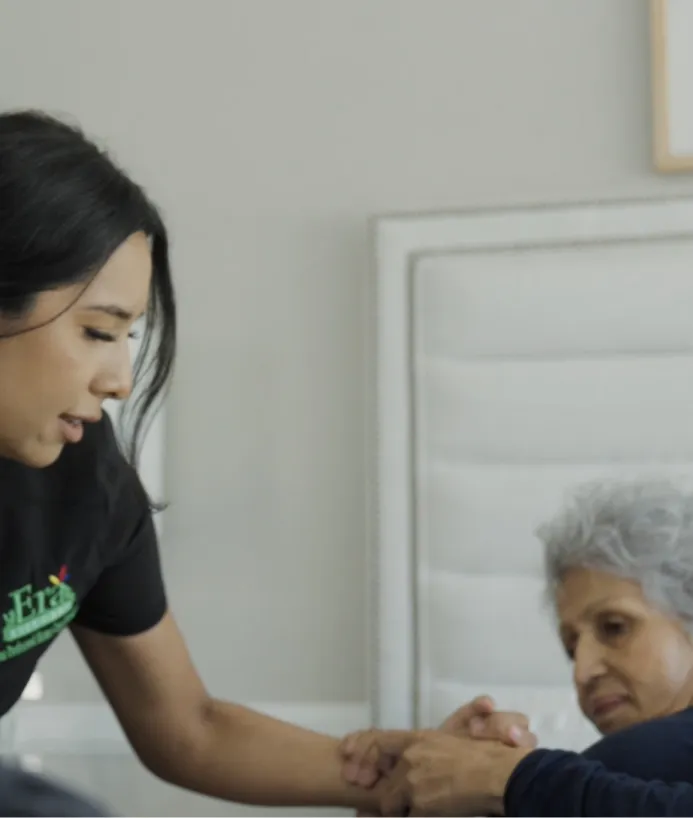 Caregiver helping patient up from bedside