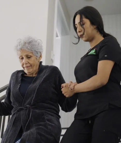 Caregiver helping patient down the stairs