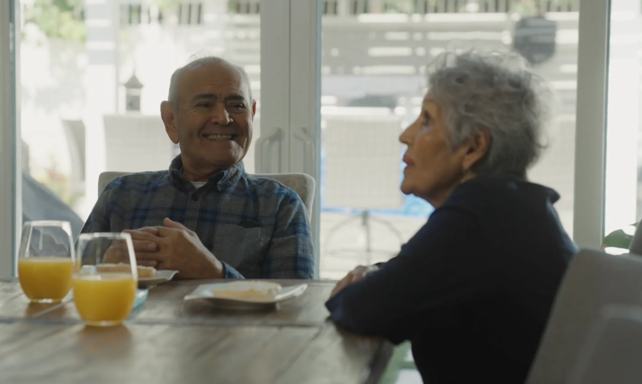 Smiling older couple sharing breakfast at their kitchen table