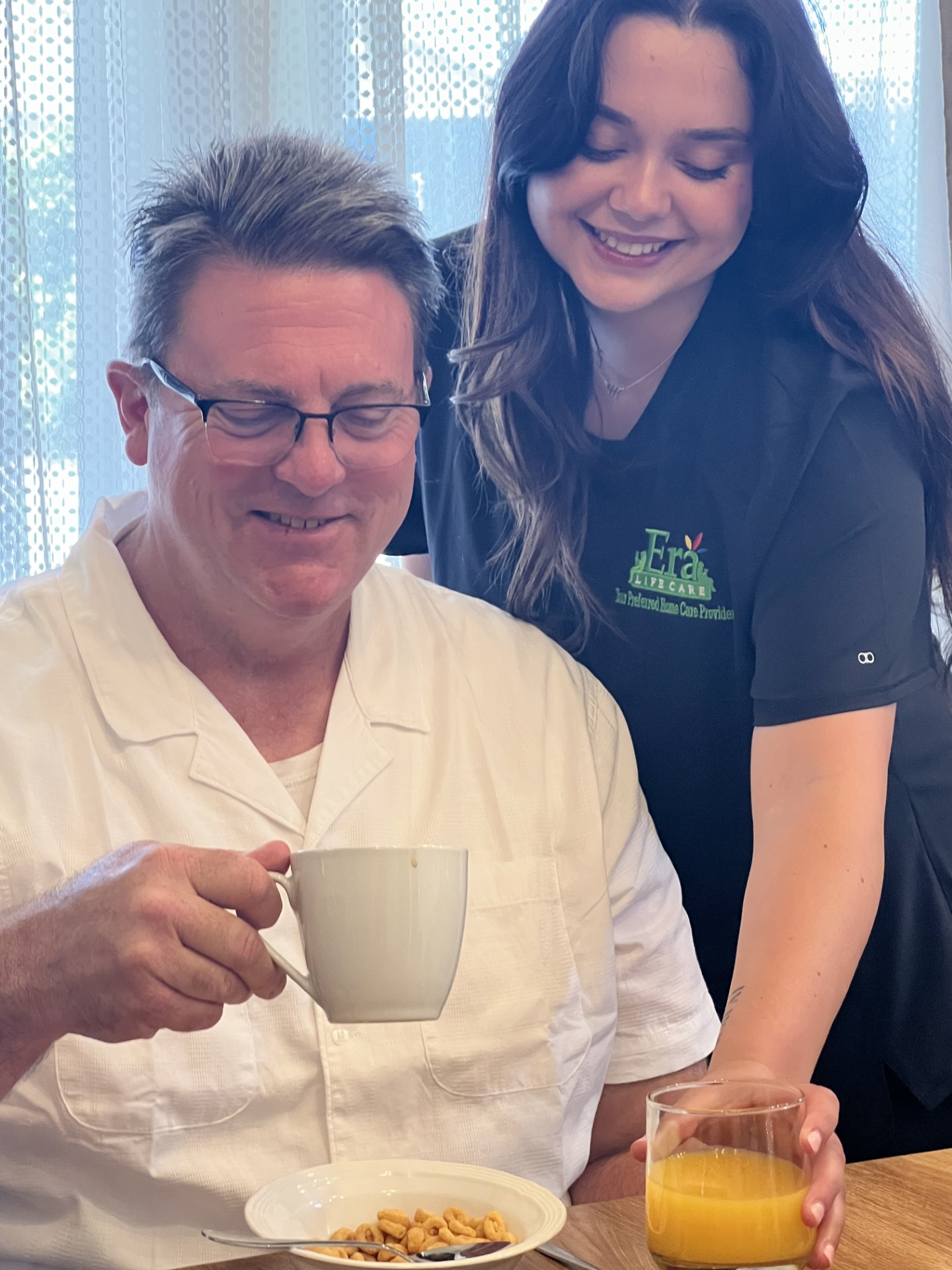 Era Life Care caregiver serving breakfast and coffee to a client