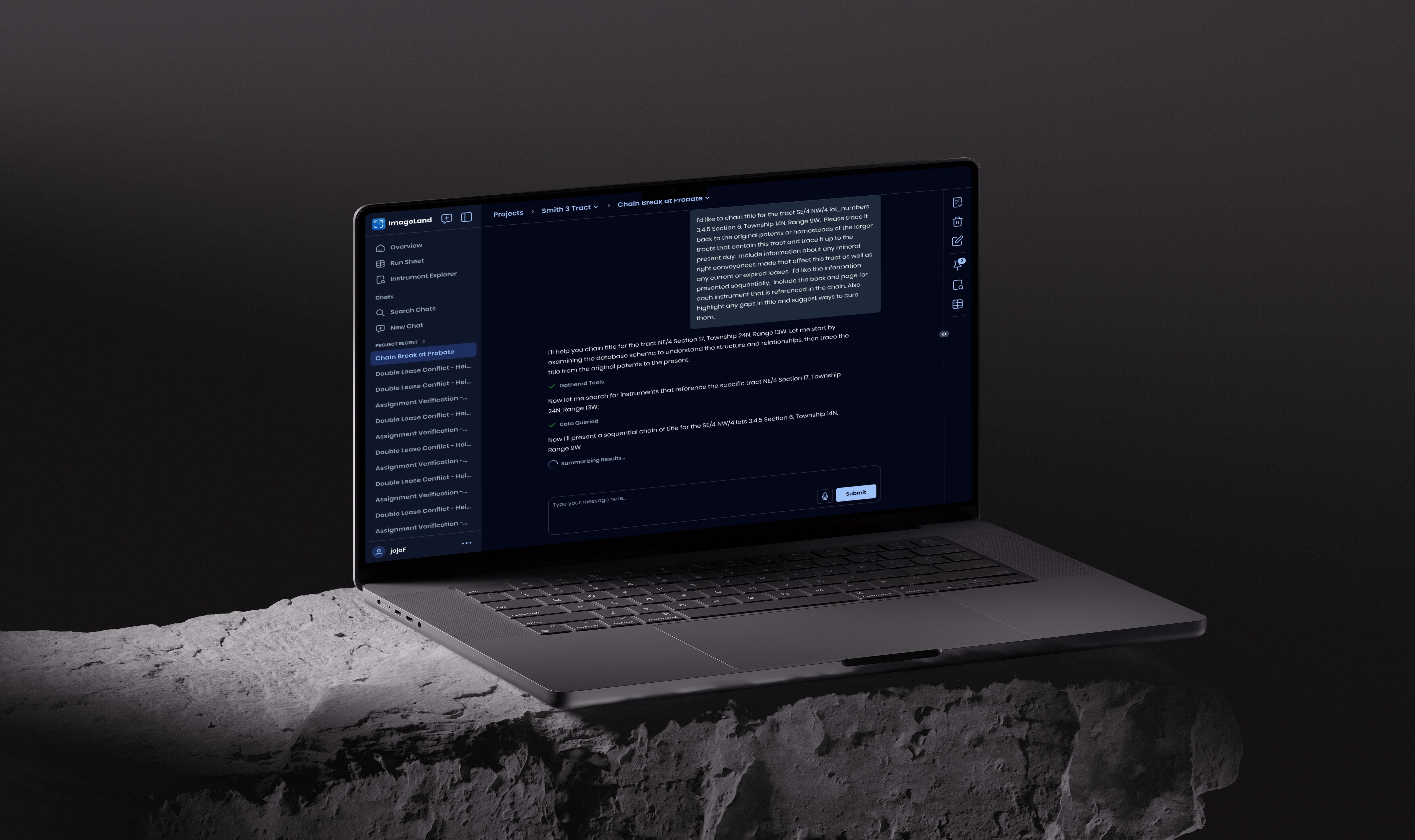 Laptop displaying Bridgeland project management interface with dark theme on rocky surface.