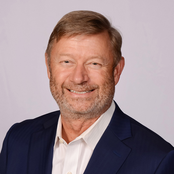 Smiling man with beard wearing navy blazer and white shirt