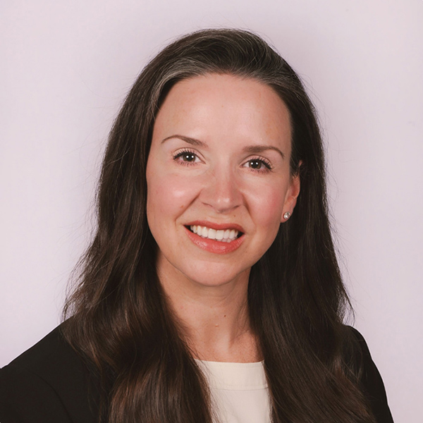 Woman with long dark hair smiling at camera wearing black blazer