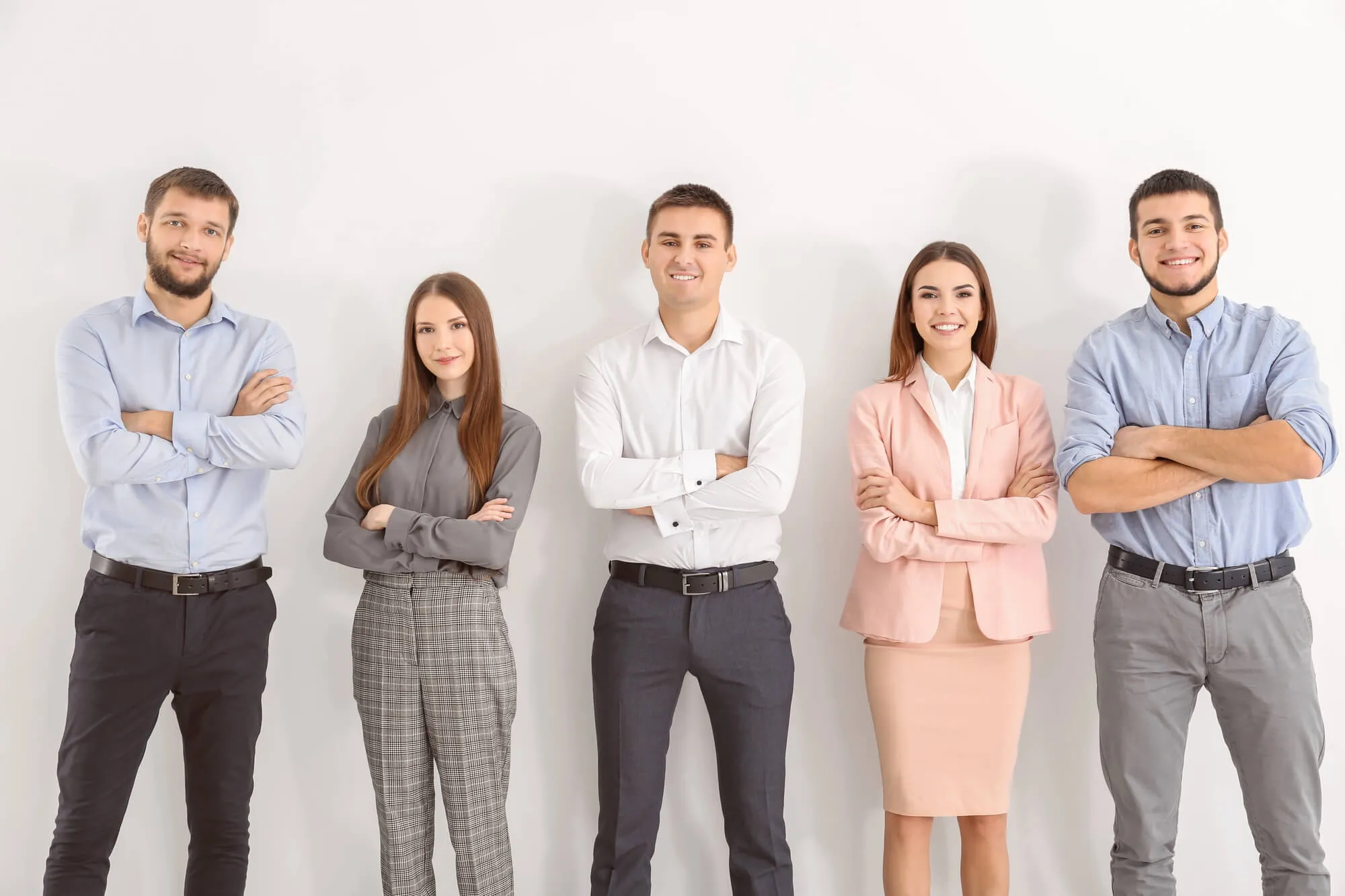 A group of five professionals standing side by side, all wearing business attire and displaying confident postures.