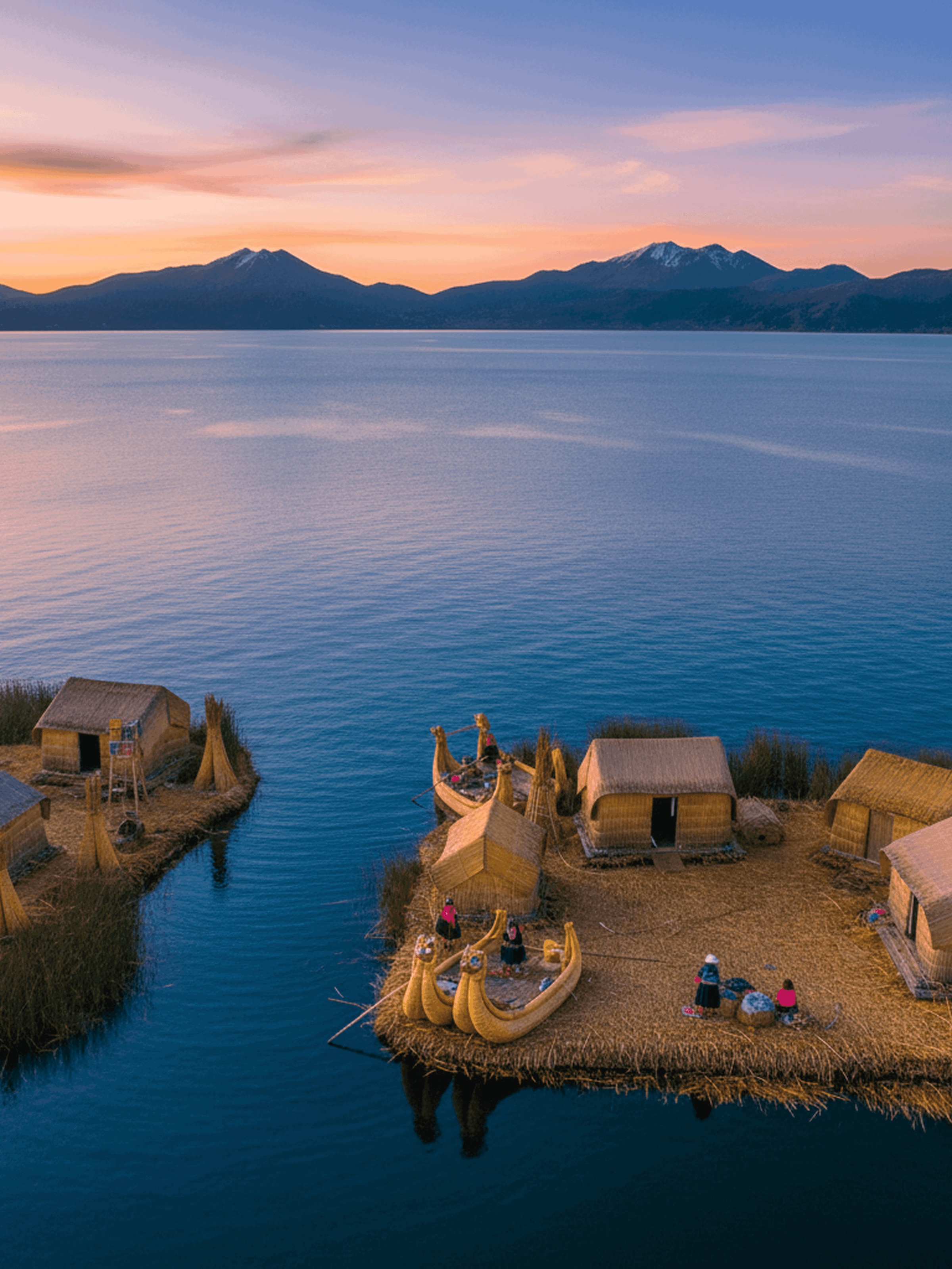 Floating reed island village on a lake at sunset with traditional boats and houses, mountains in the background.