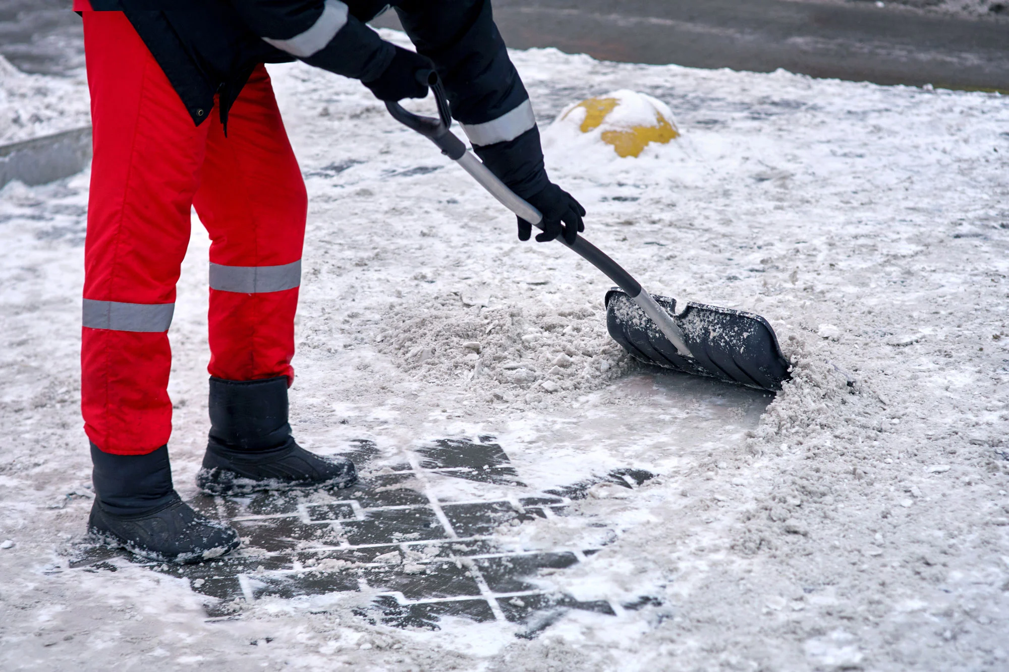 Snow removal professional clearing a driveway as part of Yardly’s winter service in Alberta.