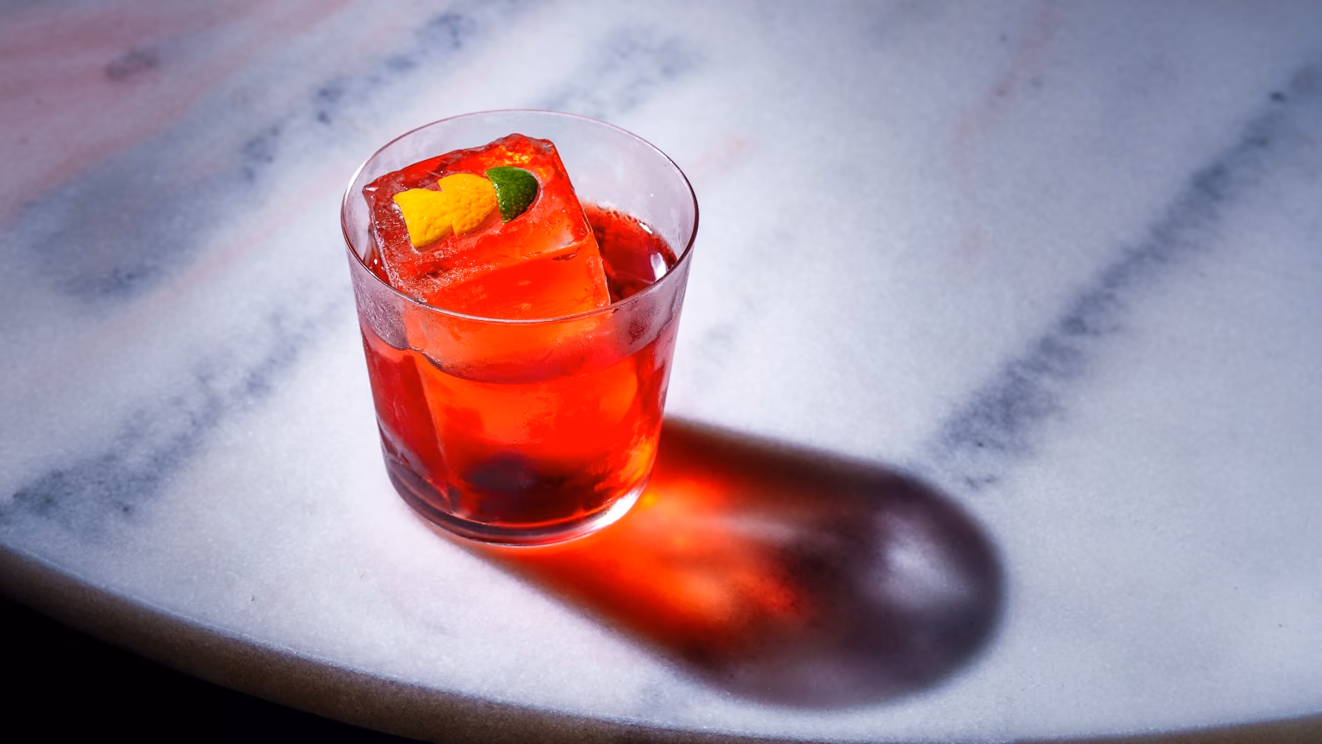 closeup of negroni drink on marble table