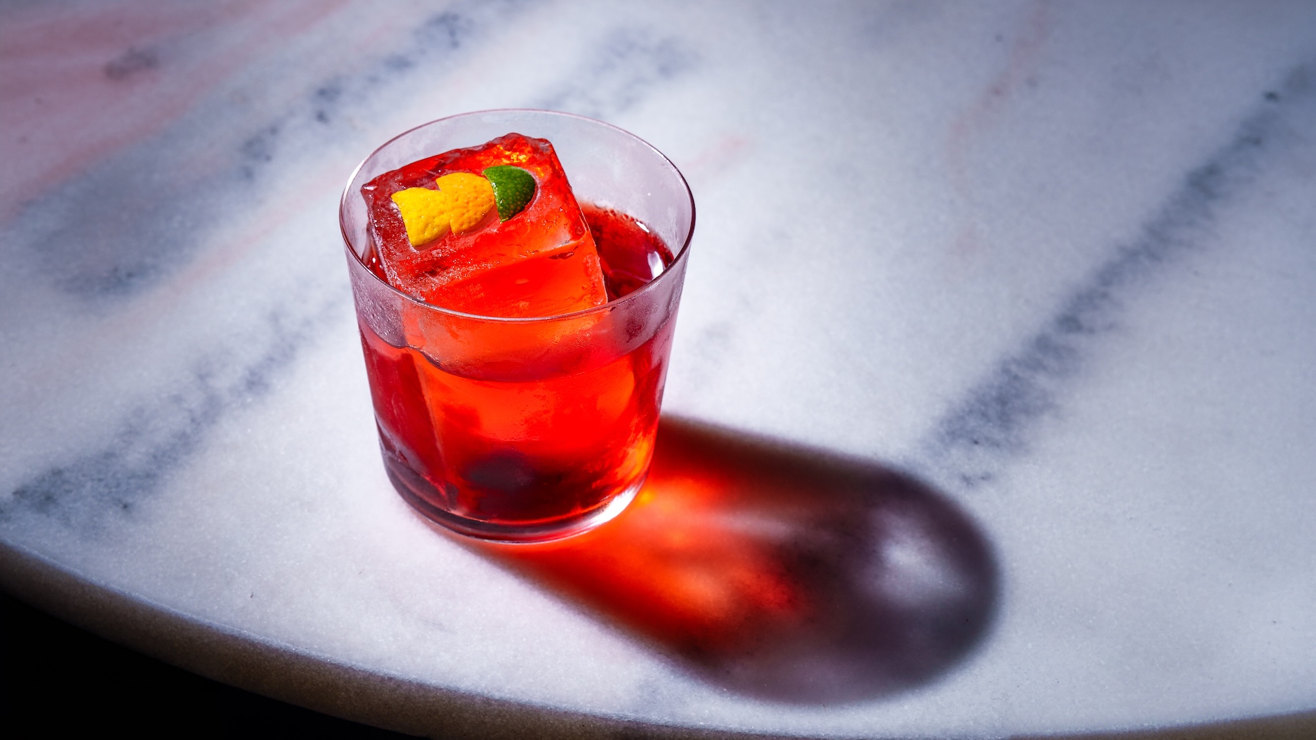 closeup of negroni drink on marble table