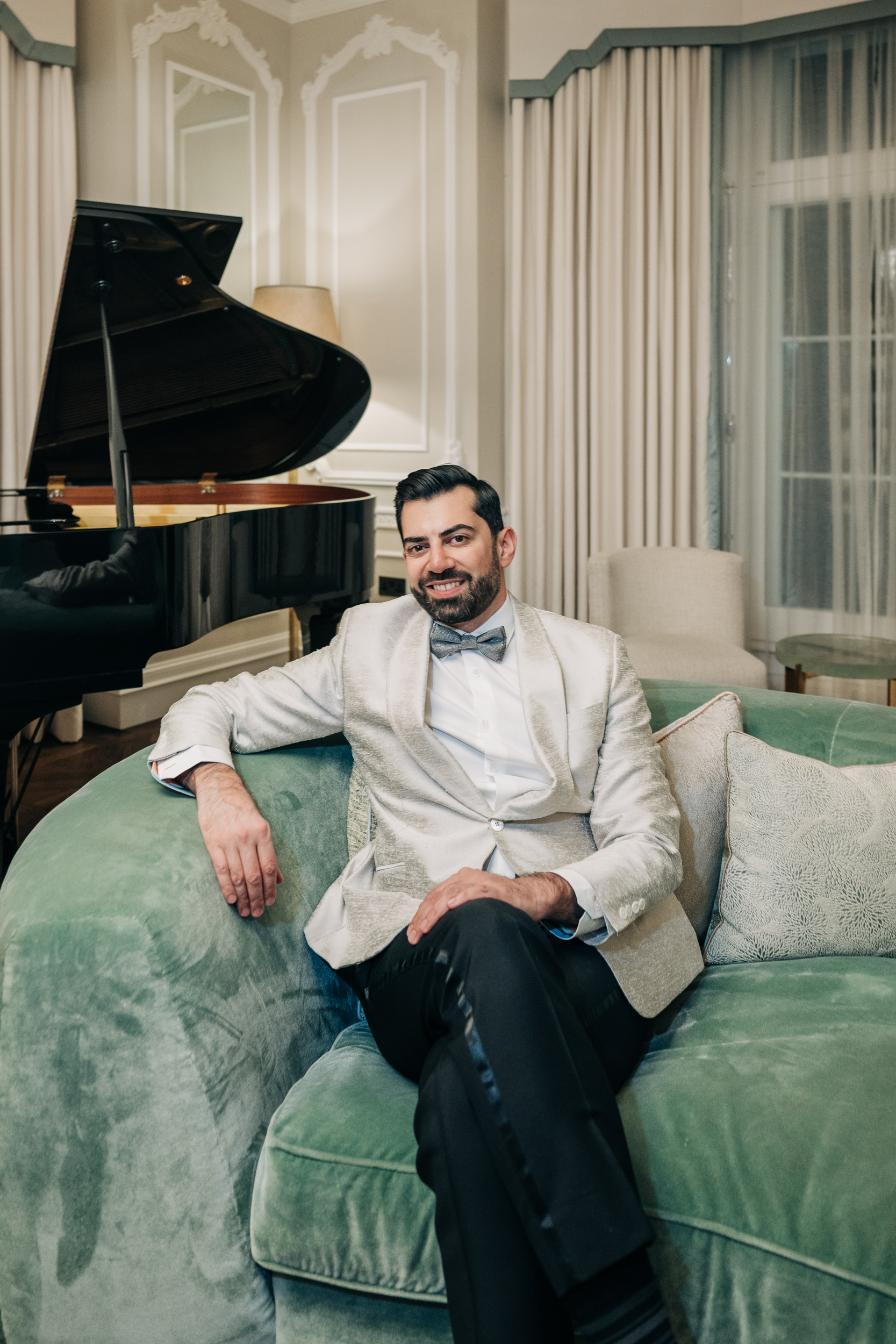 Muzz Shah, founder of Arpège, sitting in a salon featuring a grand piano