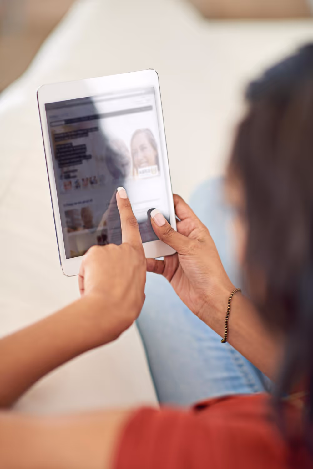 Person holding a black pen above an open book with a bright window in the background.