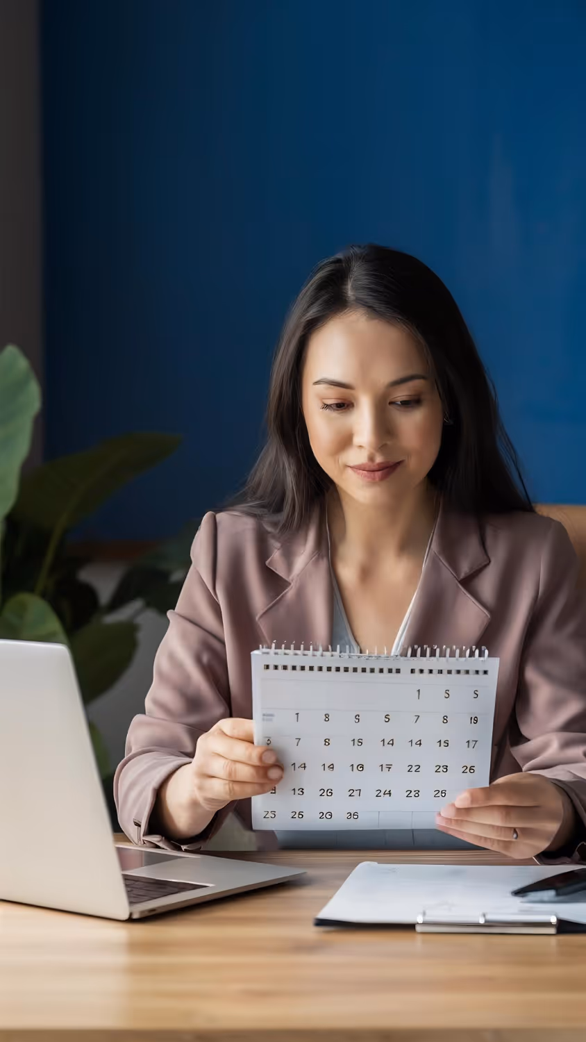 Two professionals shaking hands in an office with bookshelves in the background.