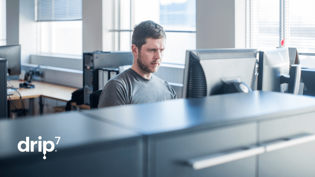 A person works at a computer in an office - signifying the importance of protecting against insider threats. 