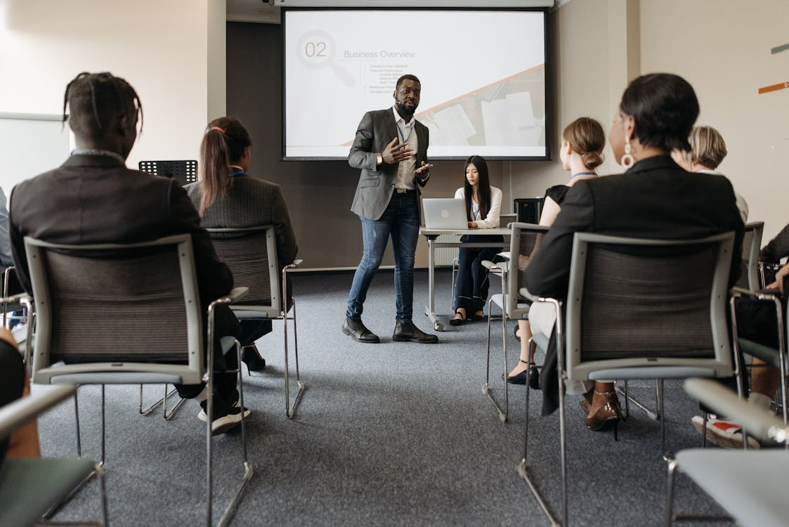 Man Standing beside Projector Screen