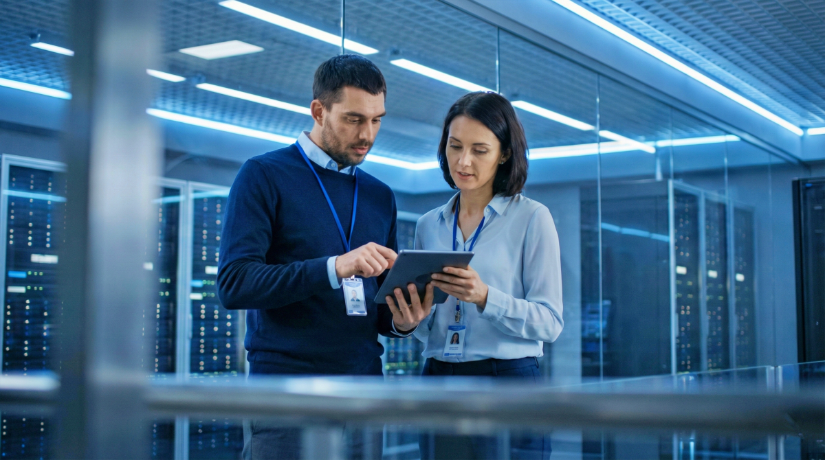 two cybersecurity professionals reviewing a tablet