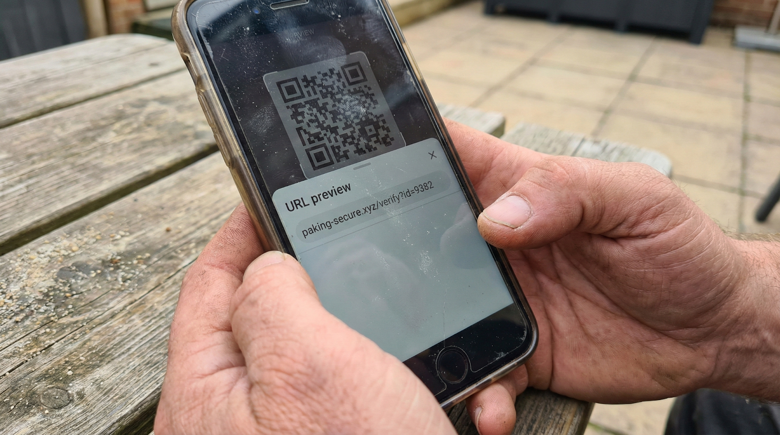 Smartphone screen showing URL preview with suspicious web address after scanning QR code