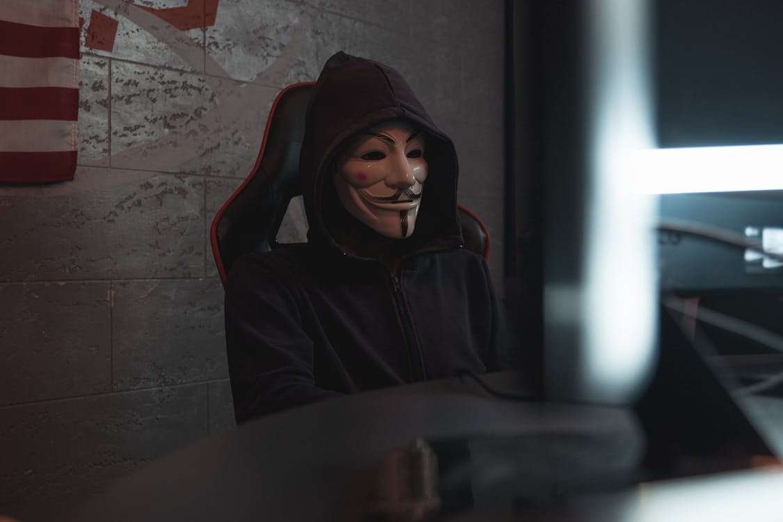  person in black hoodie hacking a computer system