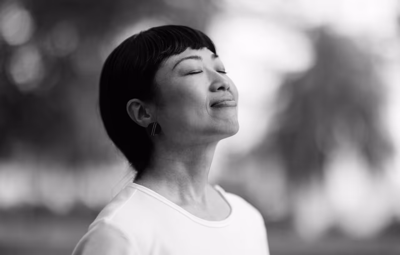 An older person smiles with eyes closed