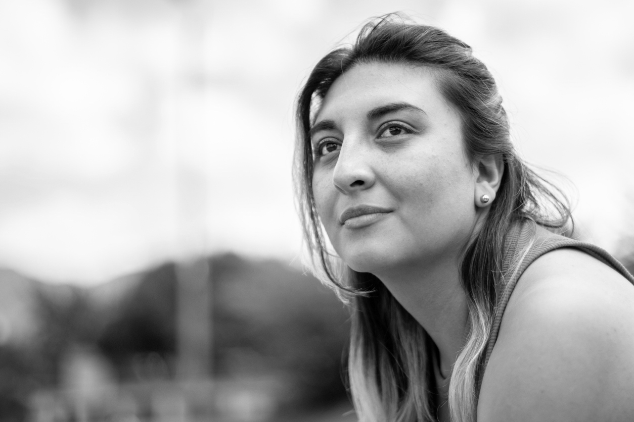 Young person looking away contemplatively while outdoors in the midday sun|Window of tolerance diagram explained in the text|Simple Diagram of WOT|Detailed Diagram of WOT