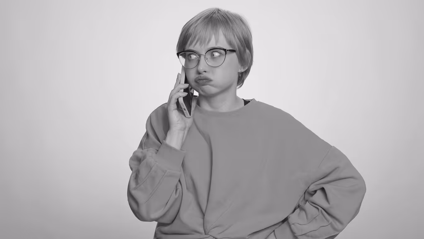 Person on their phone has a stressed look on their face as they puff their cheeks