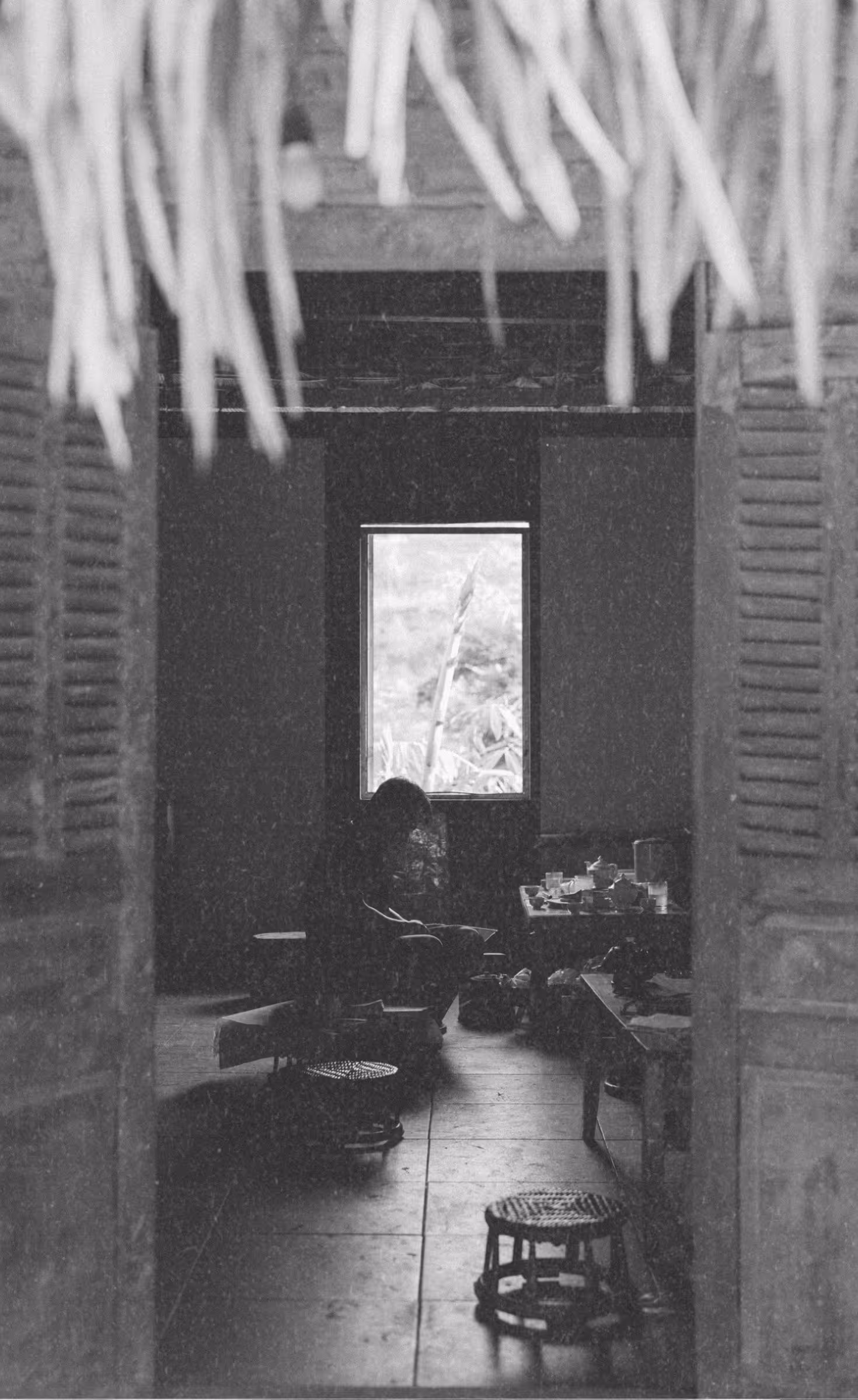 Black-and-white photo of craftsman tearing textured paper for artisanal journals