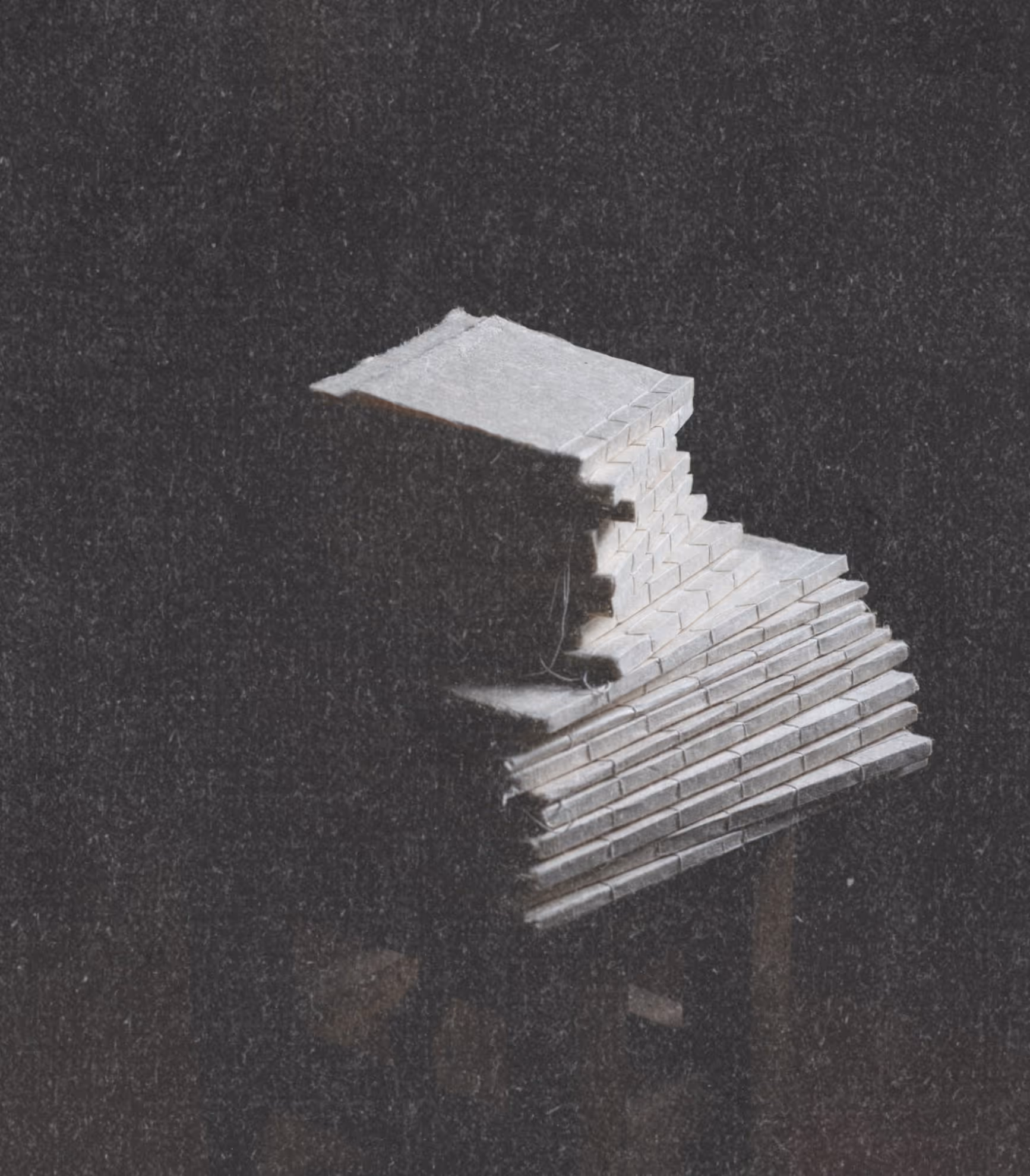 Stack of small handmade journals with varied natural paper textures in old world setting with fine art paper texture overlay.