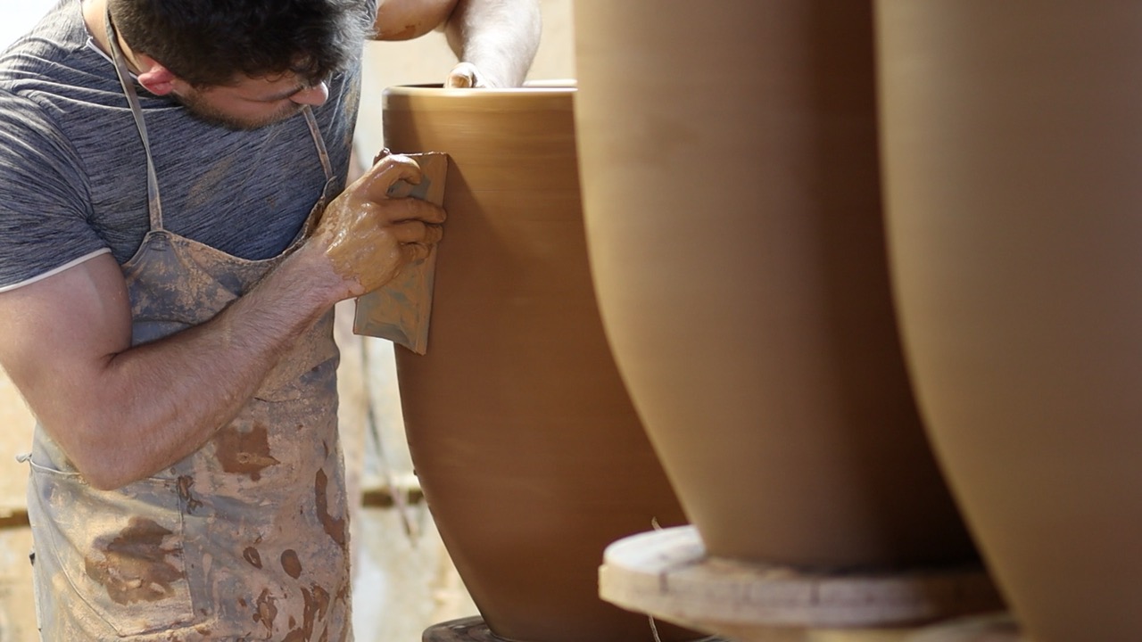 A man refining a big ceramic jar