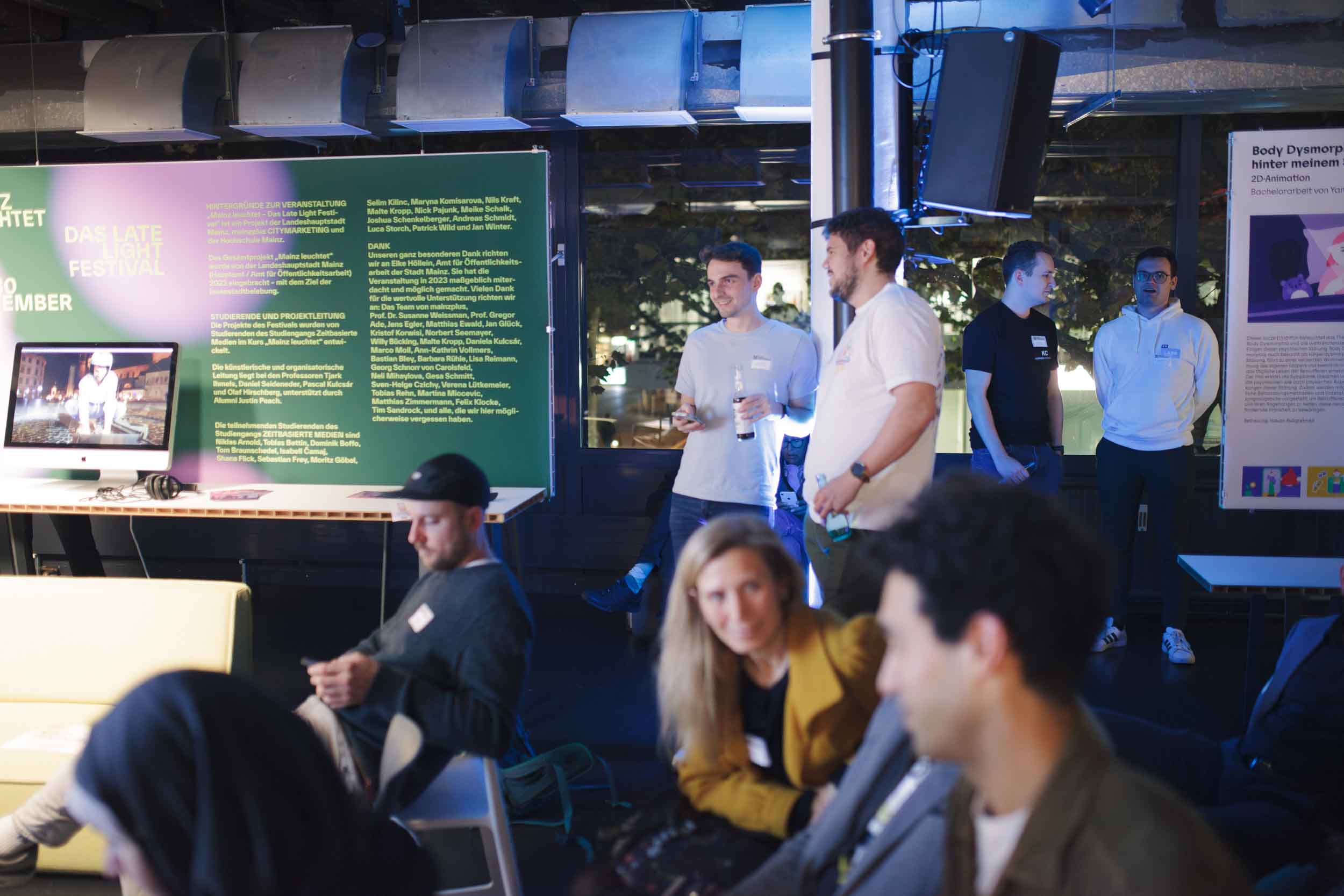 seven people sitting or standing in different groups are talking to each other