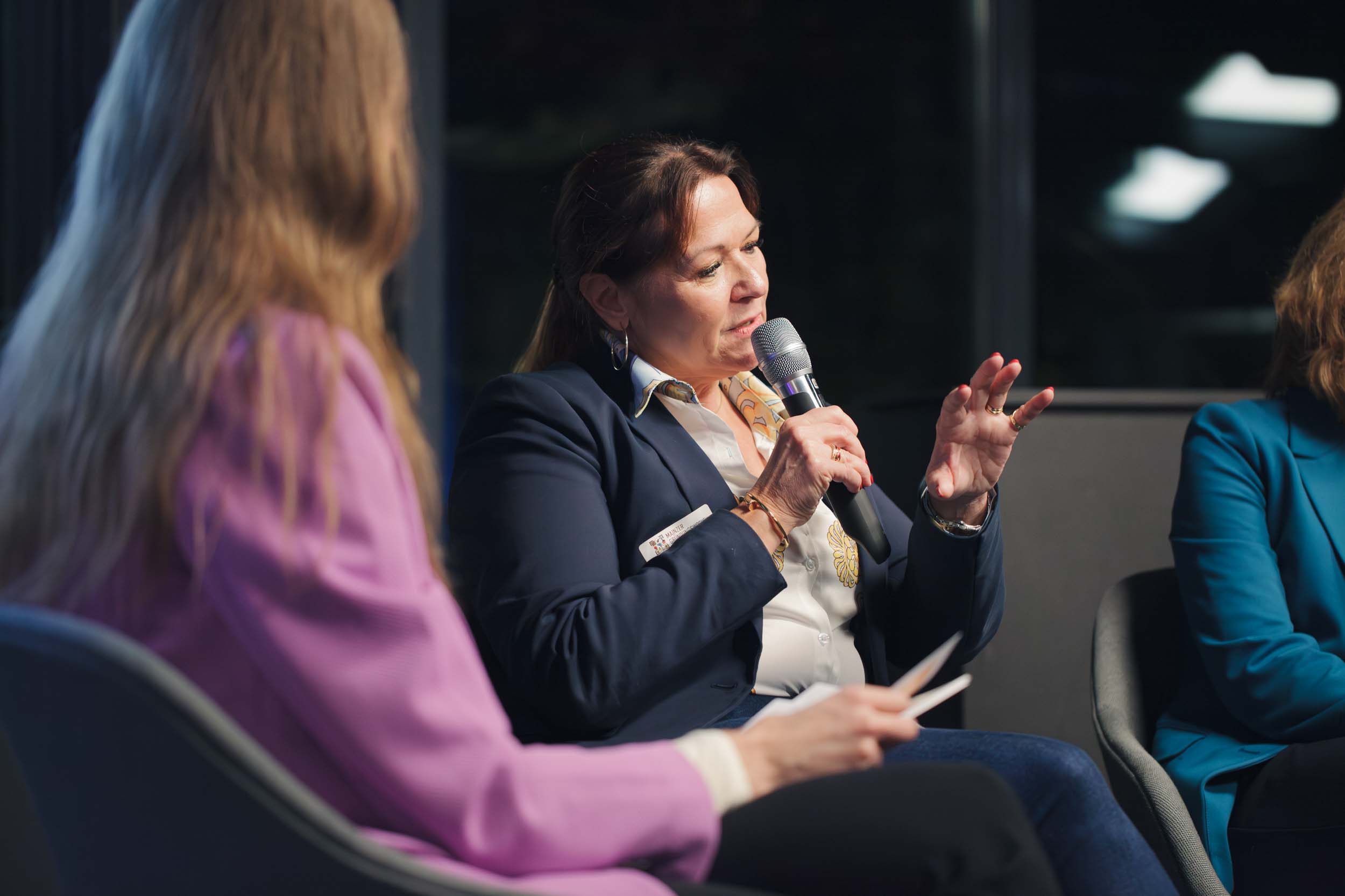 A woman with a microphone is explaining something