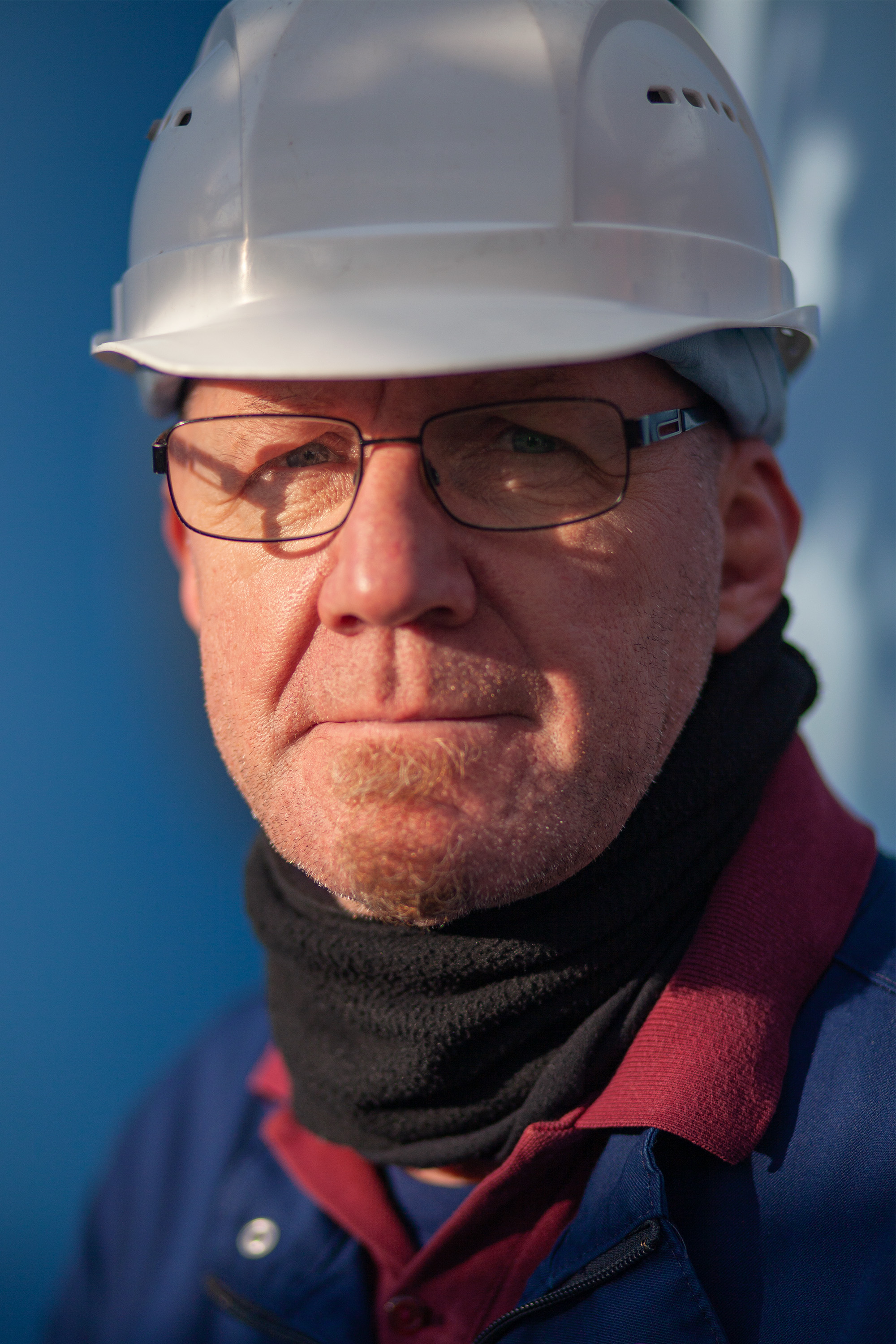 A woman with a pink jacket is sitting in front of a crowd. She is talking to someone of the crowd