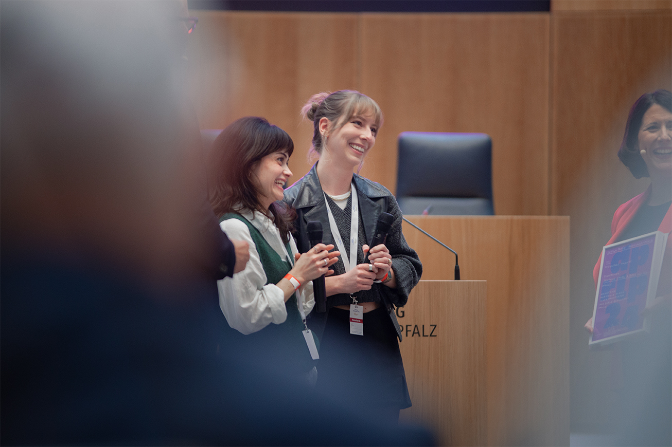 Five people in front of a crowd are discussion