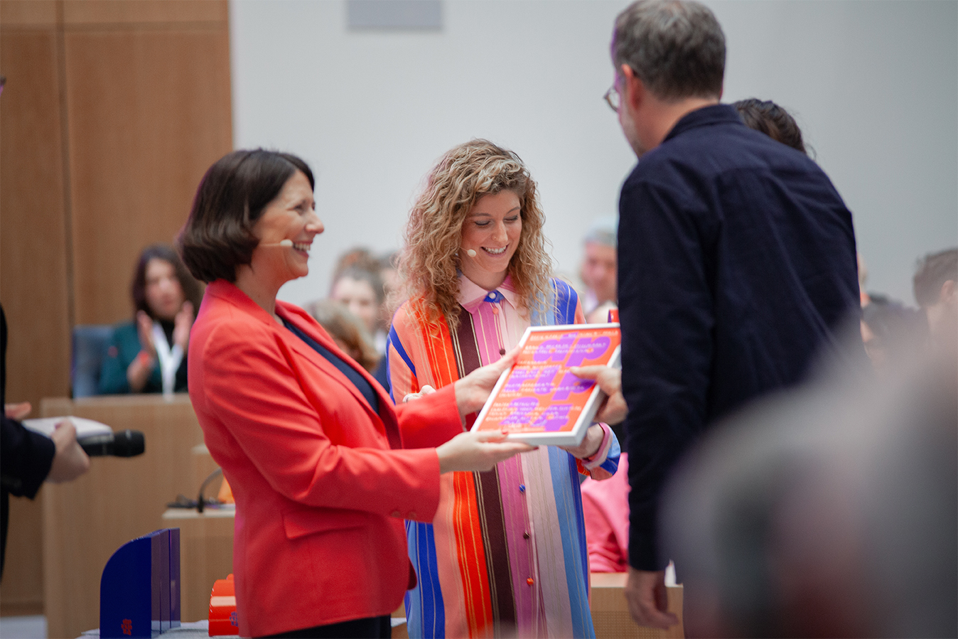 A woman with a microphone is explaining something