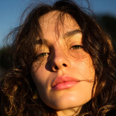 Portrait of a woman with curly hair featured in BYQ Supply customer testimonial.