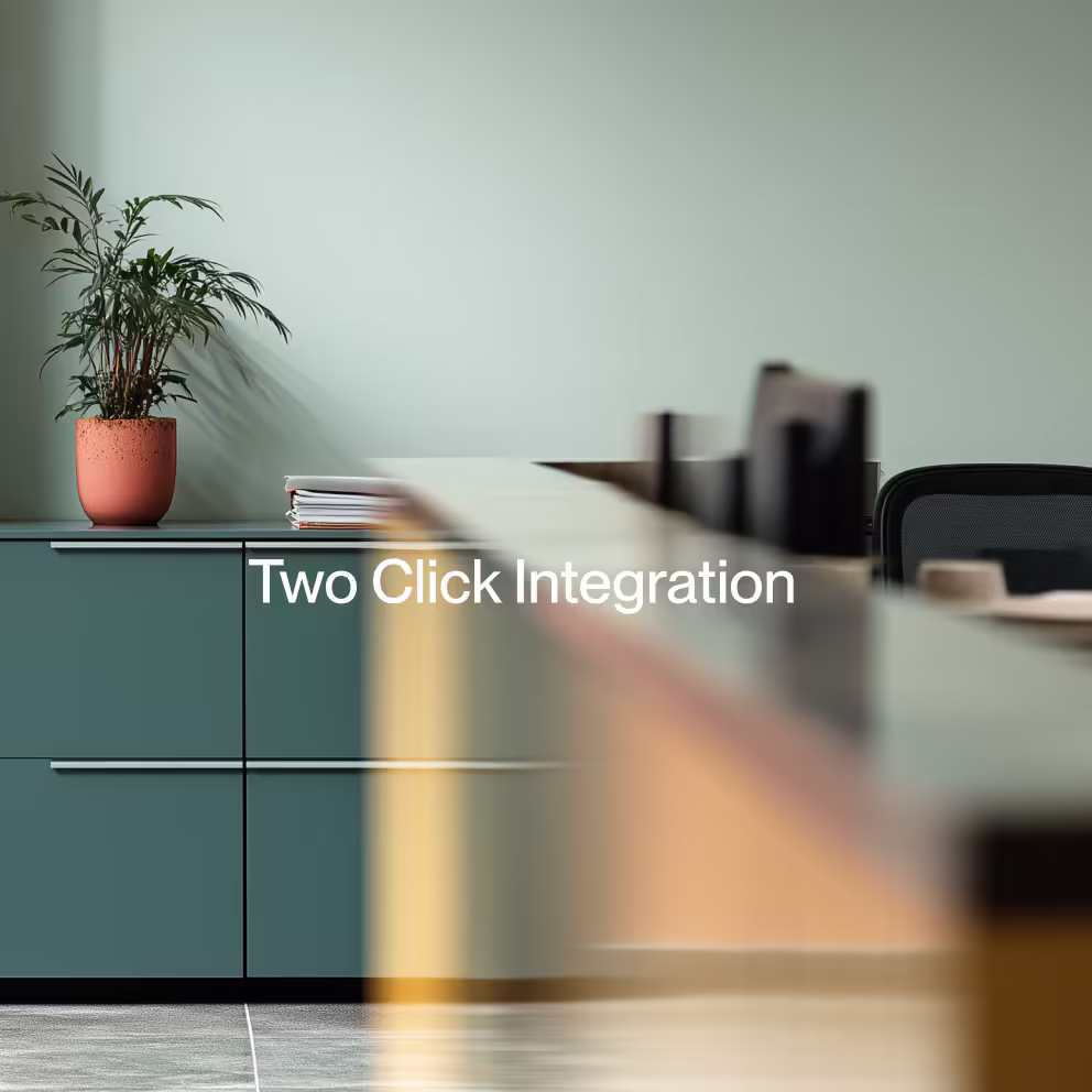 Modern office interior with green cabinets, a potted plant, and blurred desk items in the foreground with text 'Two Click Integration'.