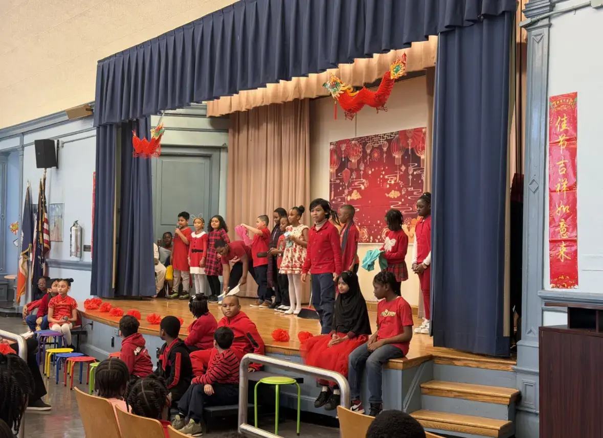 Students performing on stage during Lunar New Year school celebration