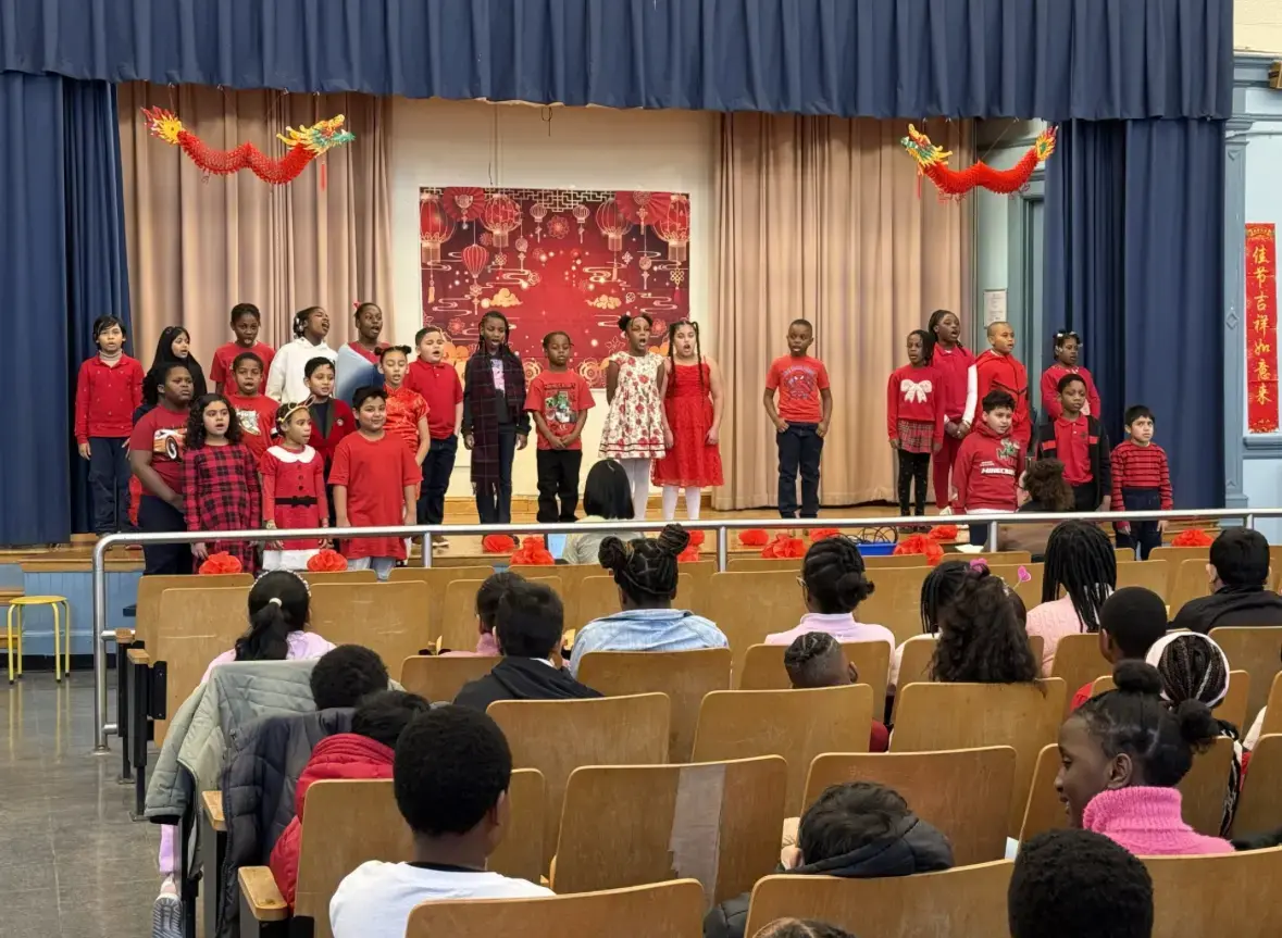 Students perform on stage during a Lunar New Year school assembly