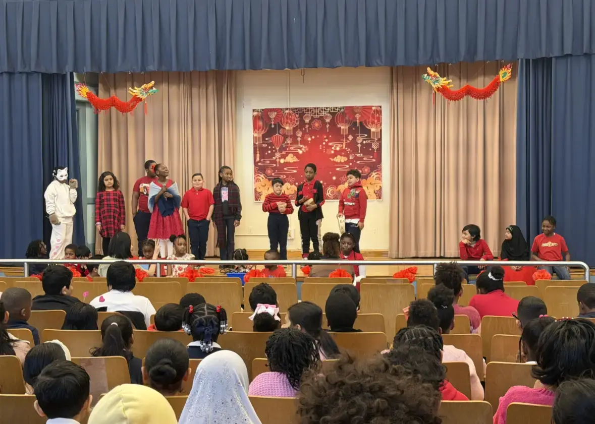 Students performing Lunar New Year show on school auditorium stage