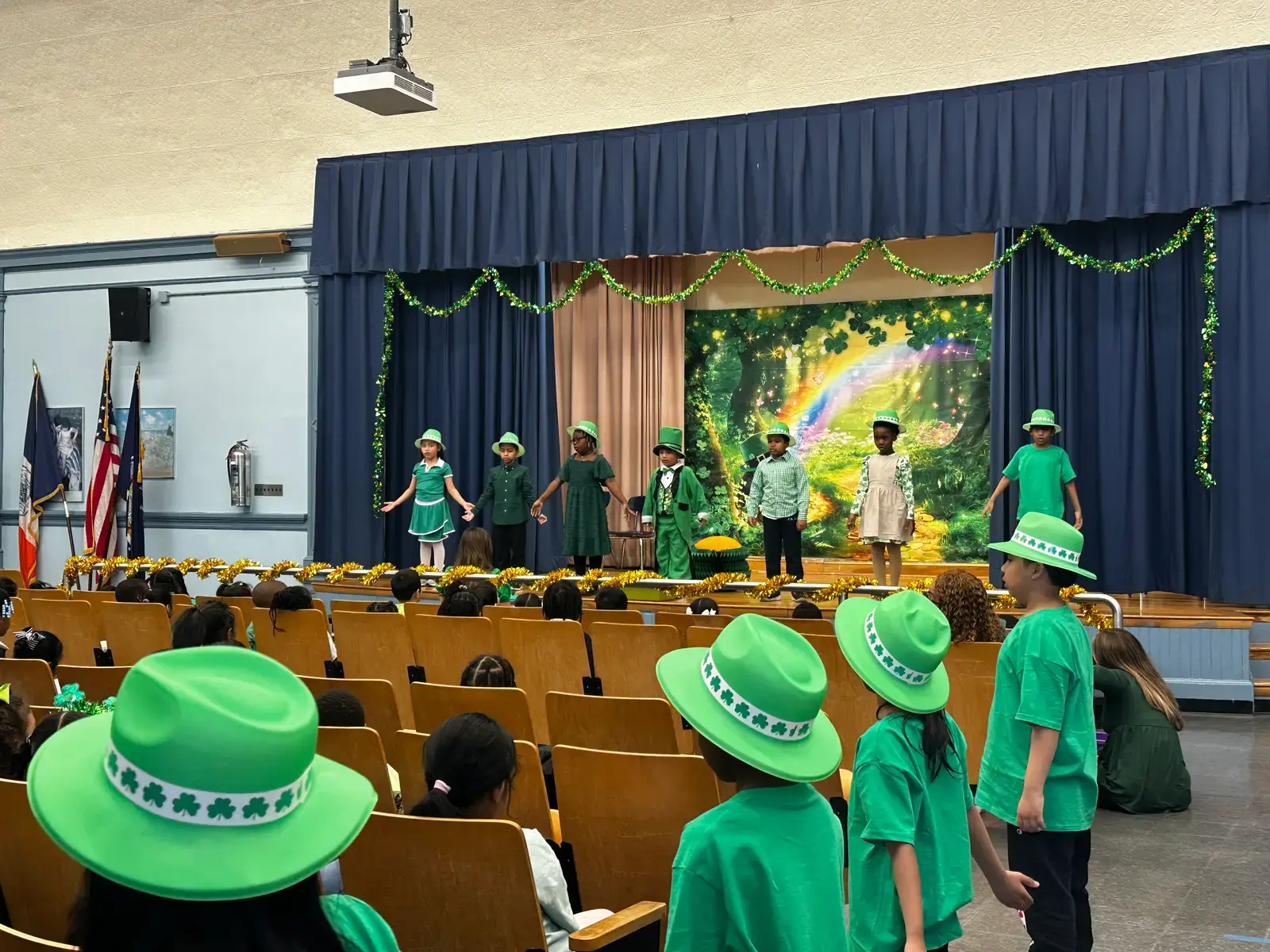 Students perform Saint Patrick's Day show on decorated school auditorium stage