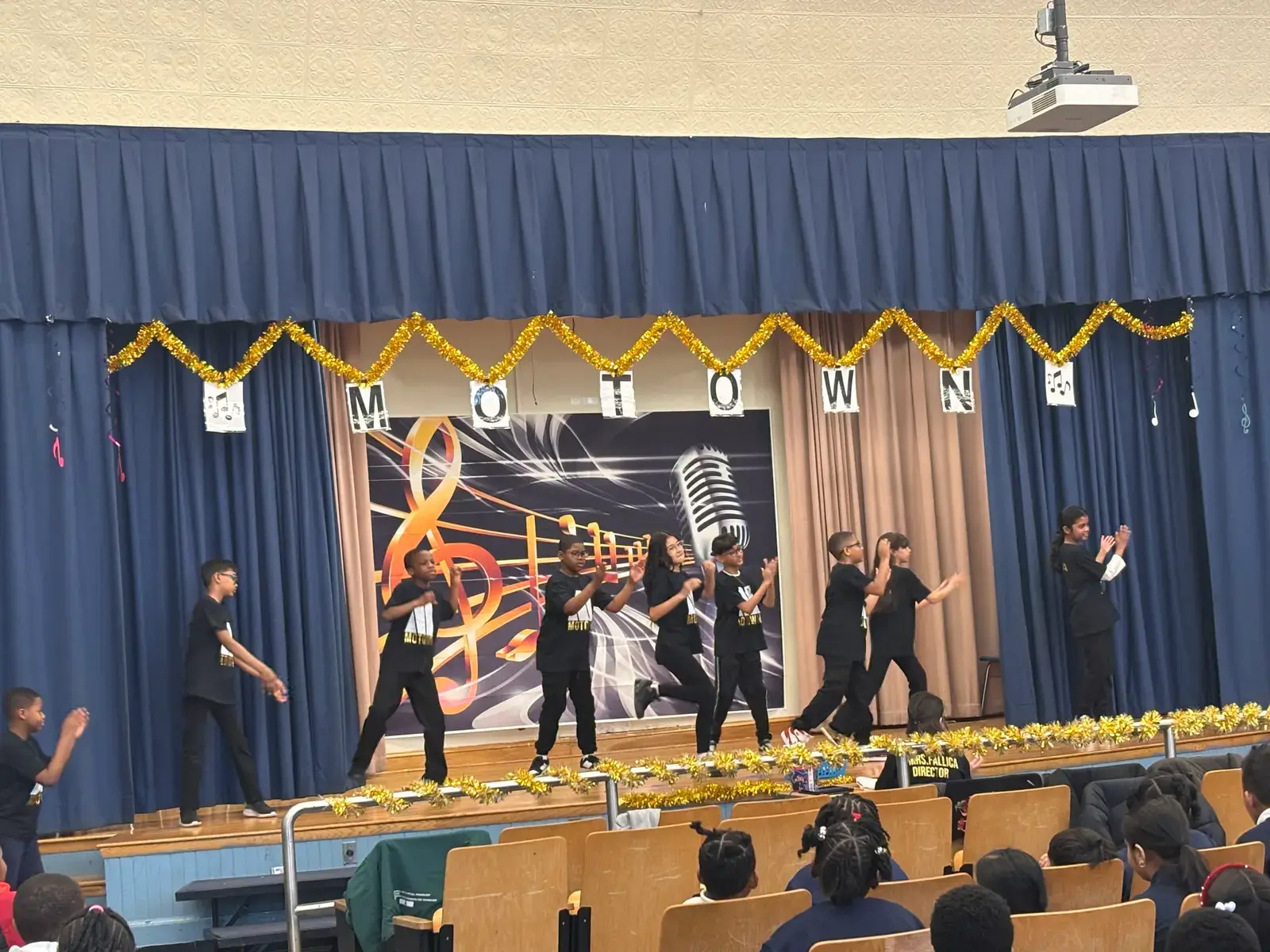 Students performing on stage at a Motown-themed school show