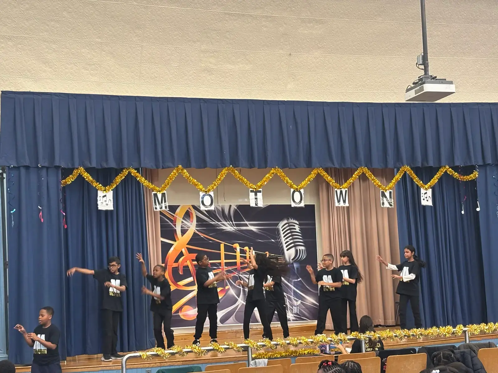 Students performing a Motown themed dance show on school stage