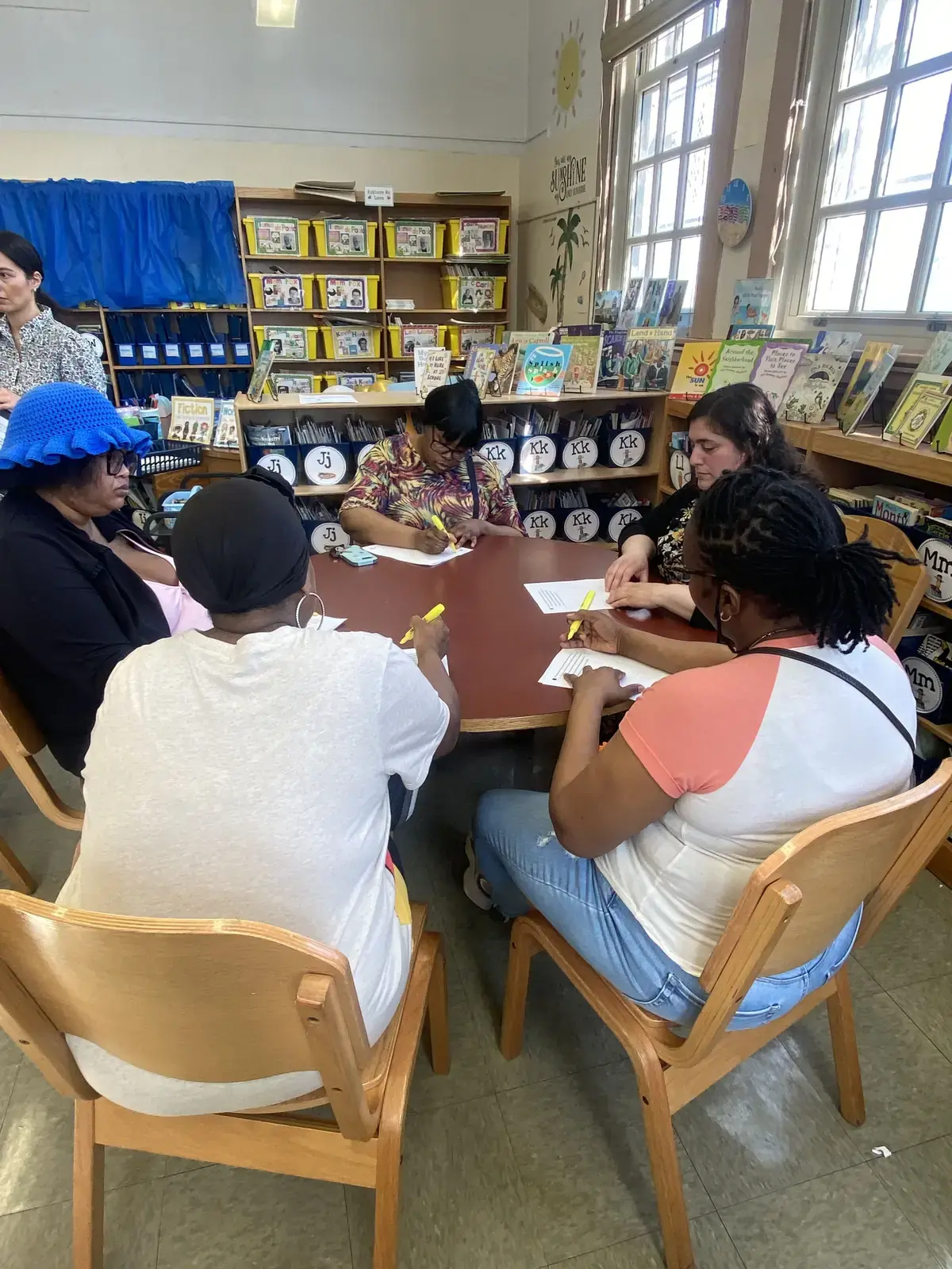 Adults reviewing documents together at a school library table