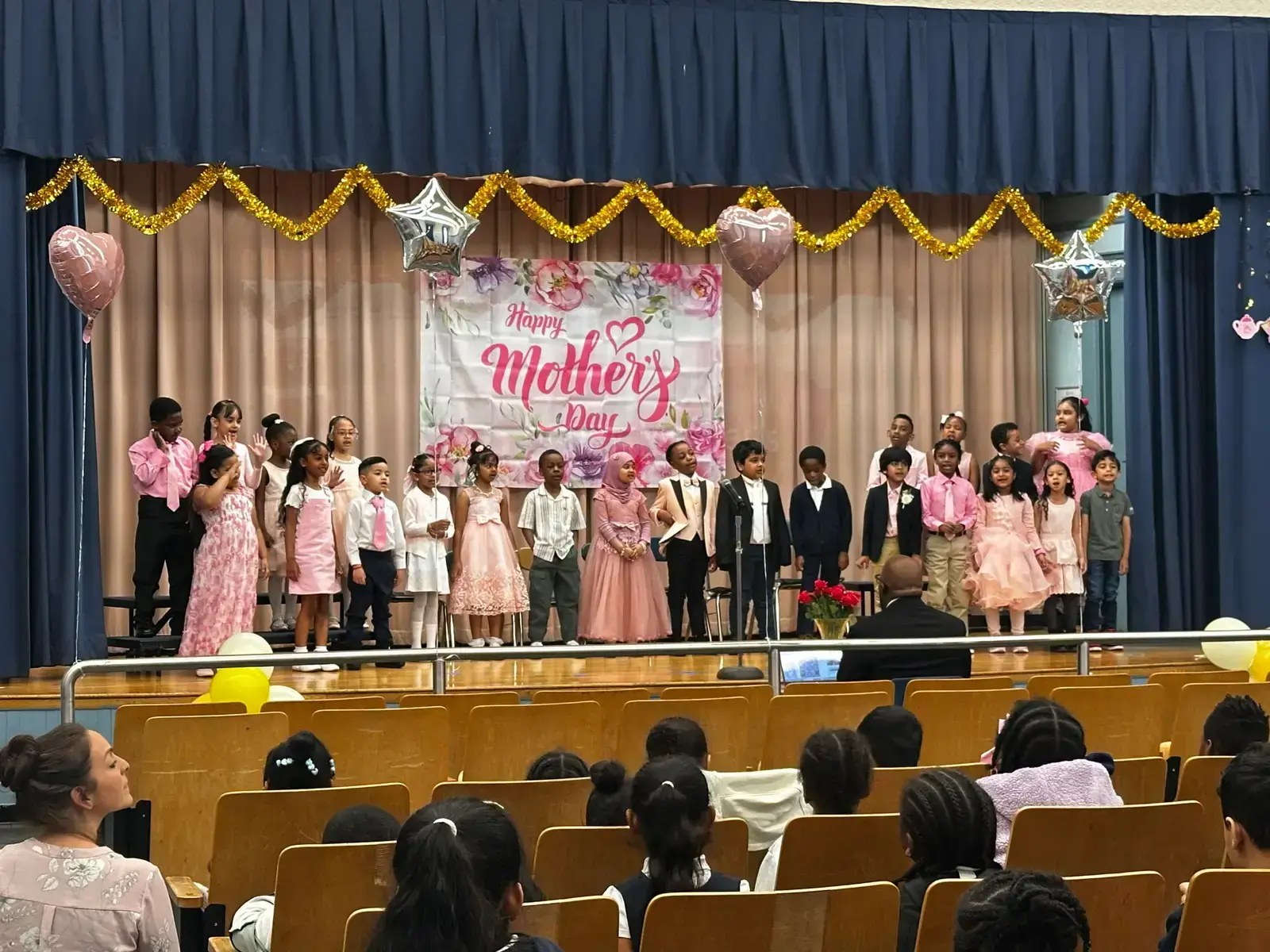 Students performing on stage at a school Mother's Day celebration