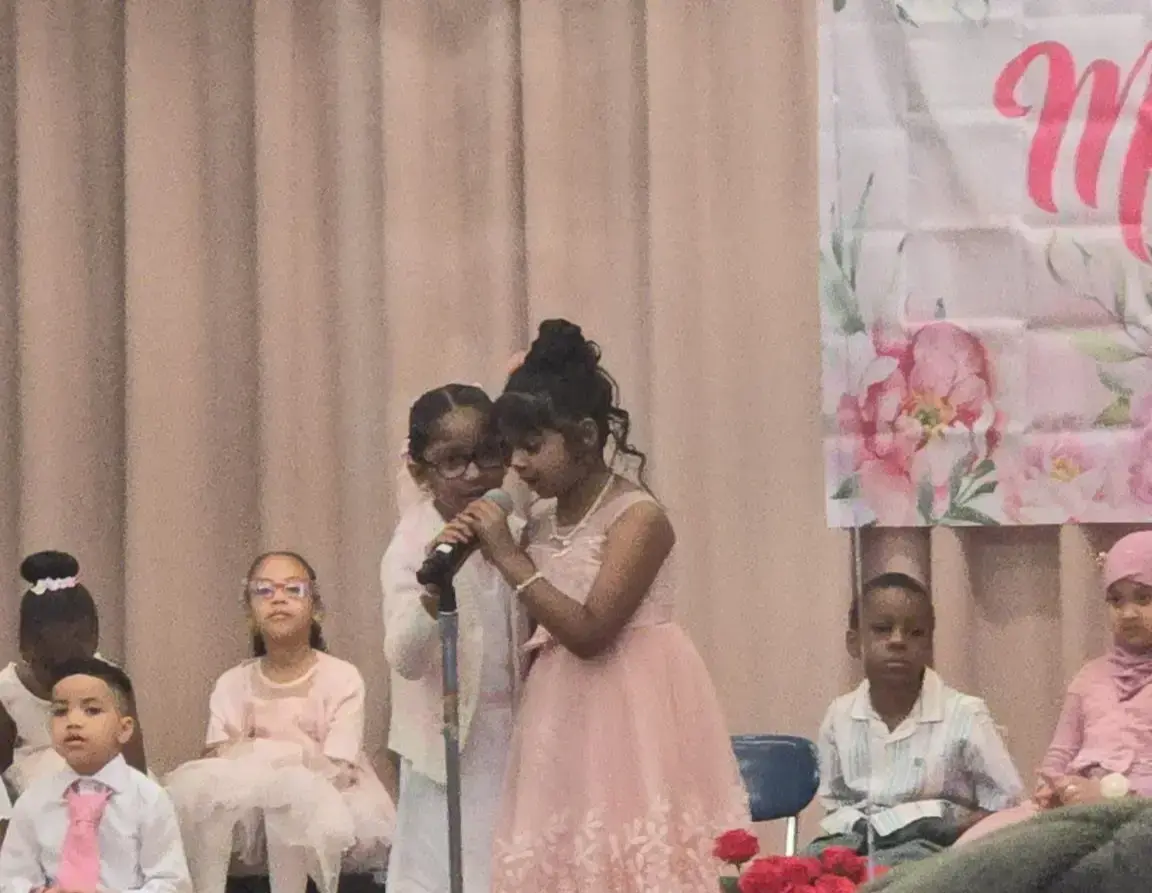 Student speaking into microphone on stage during school performance