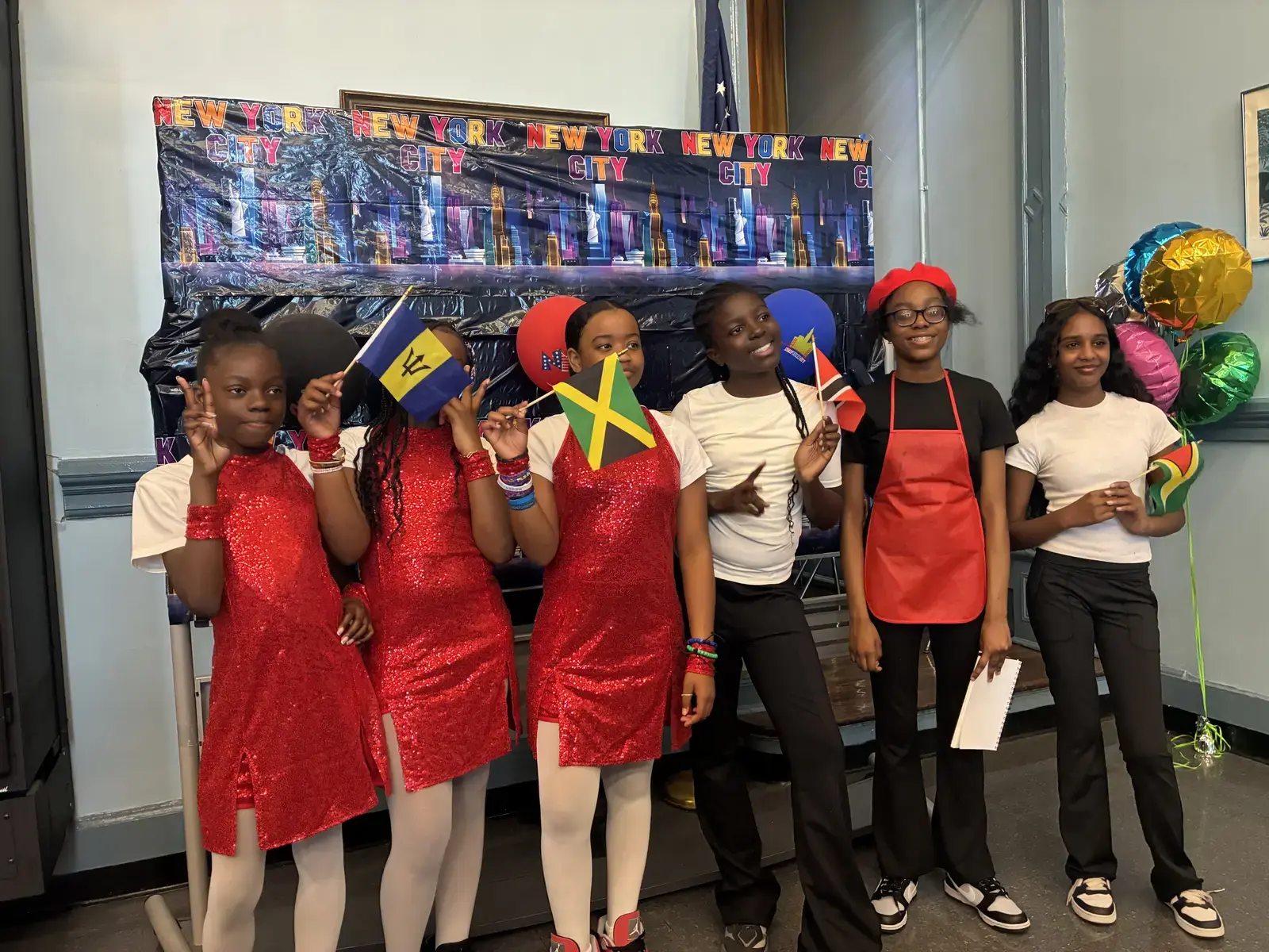 Students holding Caribbean flags at a school cultural celebration event