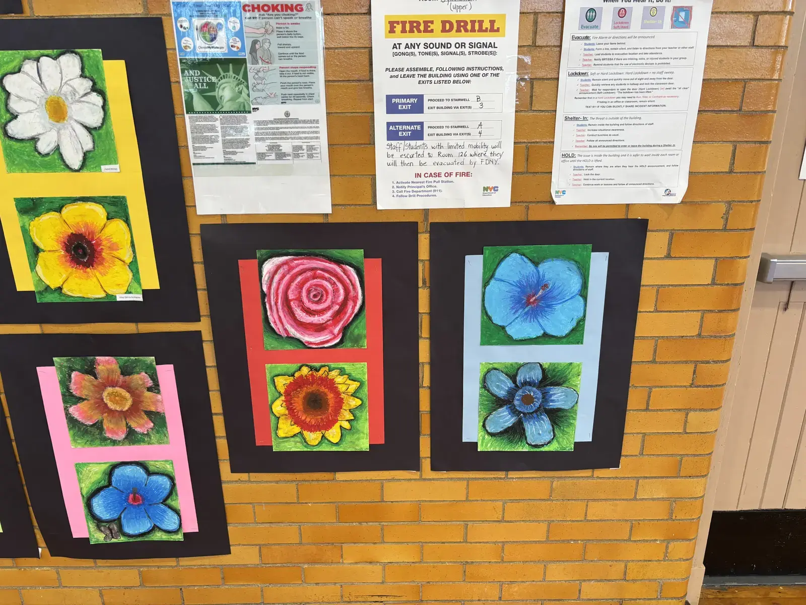 Student artwork displaying colorful painted flowers displayed on hallway wall
